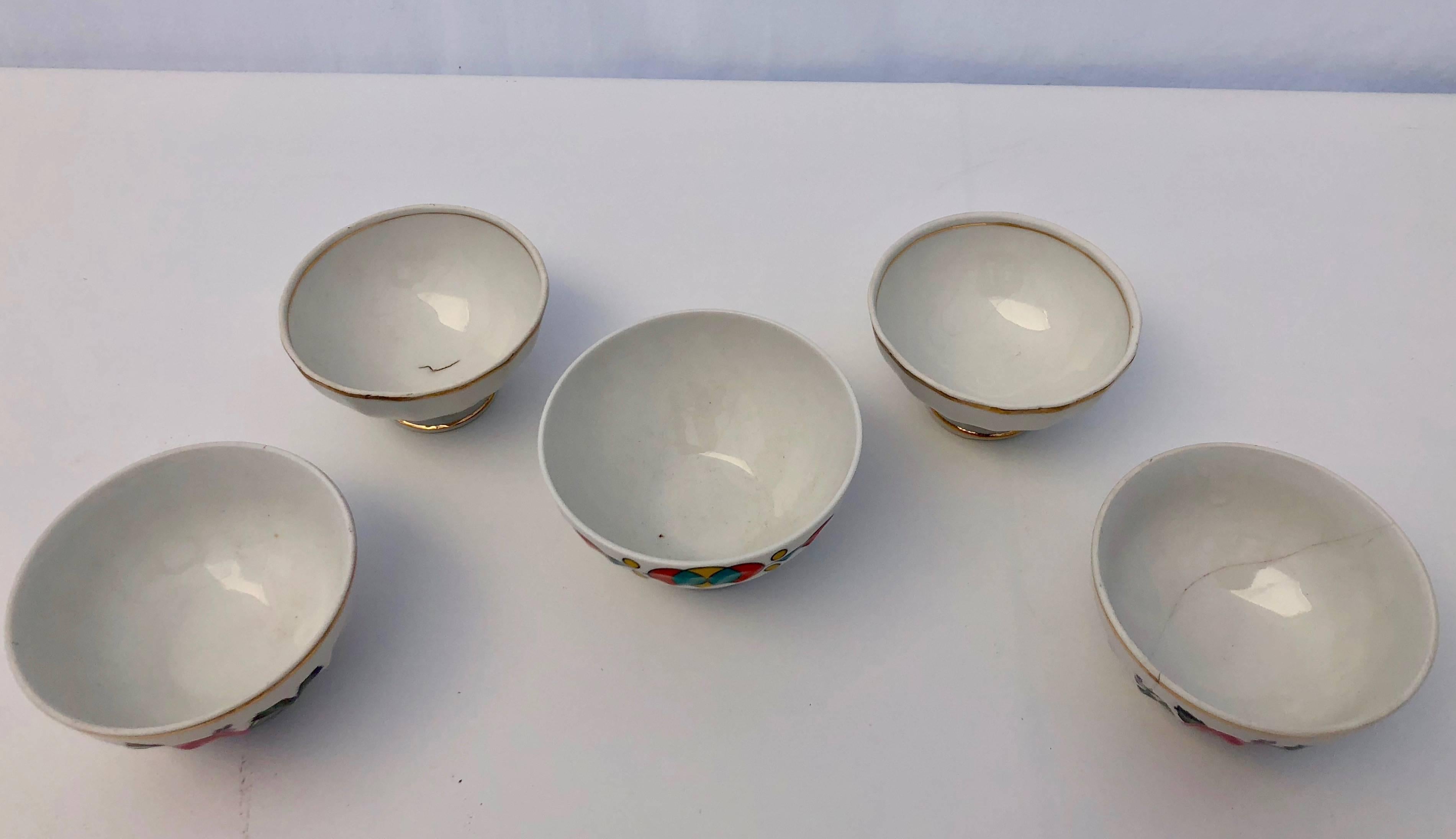 These small antique French bowls are not often found. There are five in the lot and all have a white background. A set of two have gold trim while another set of two are painted with a floral design and have gold trim at the top. A single bowl has a