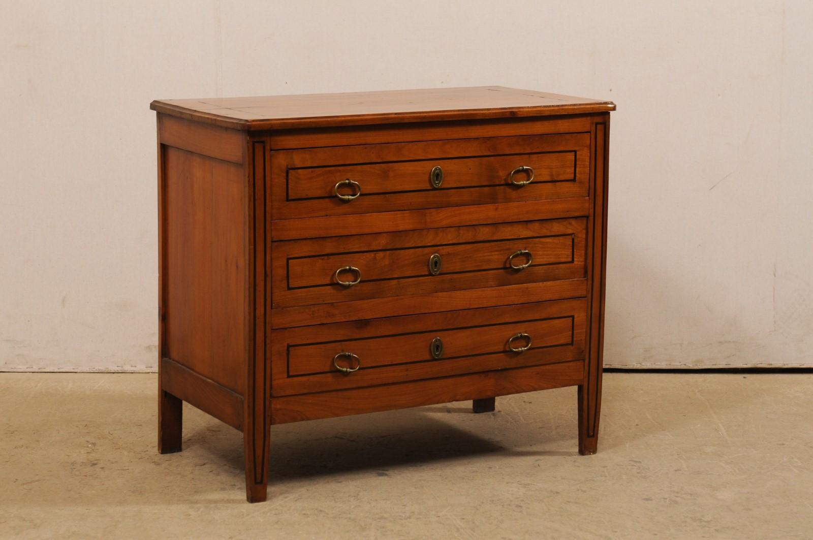 A French commode from the early 20th century. This antique chest from France features a rectangular-shaped top with a case which houses three dovetailed-drawers, and is raised nicely upon four squared legs, with front pair gently tapering at their