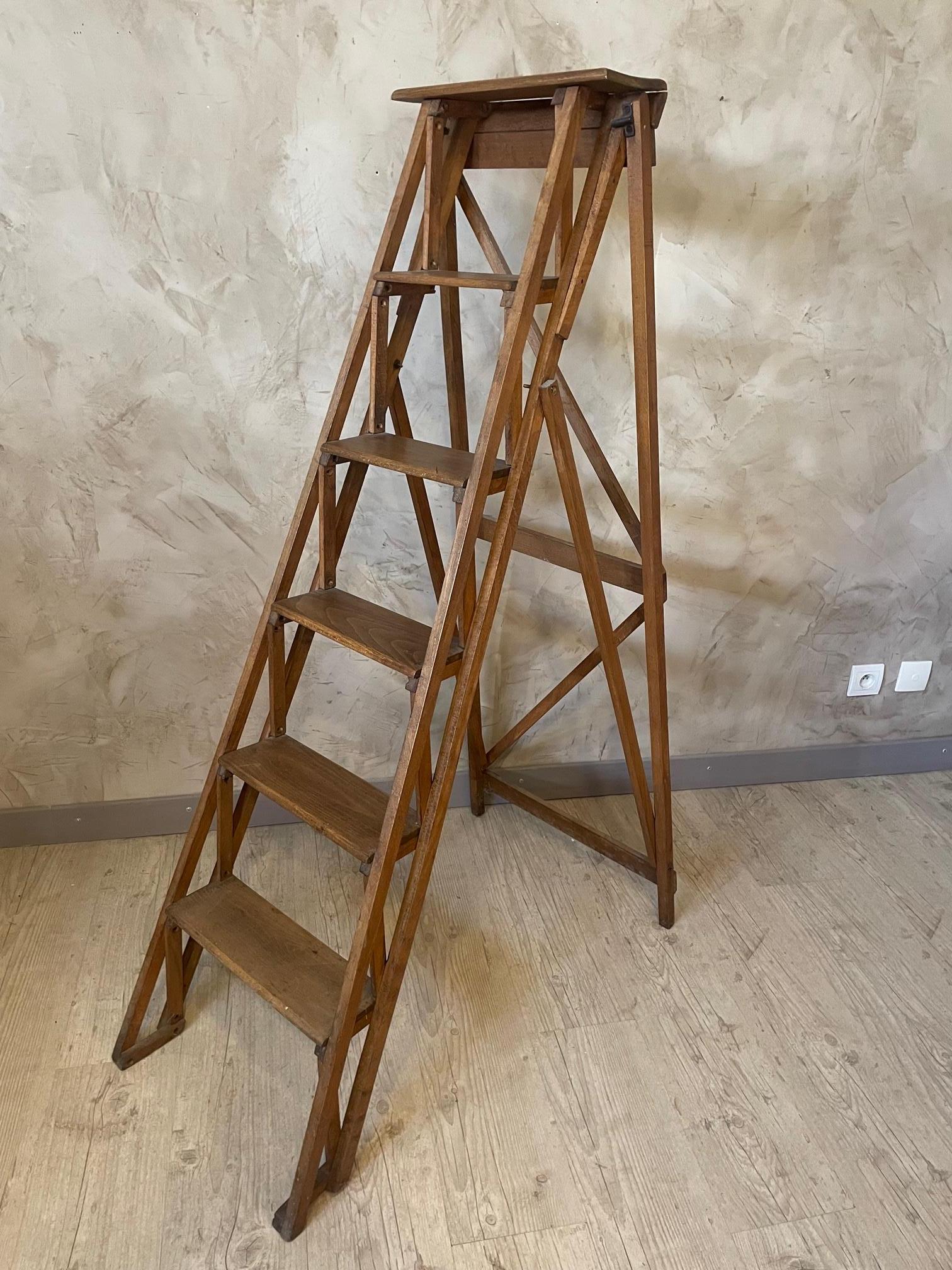 Very nice French walnut stepladder or set of library steps with wonderful patinated hinges, a good opening mechanism and interesting distress. 
Quite sturdy but will be better to use it for decoration.
Good color and a good look for any room.