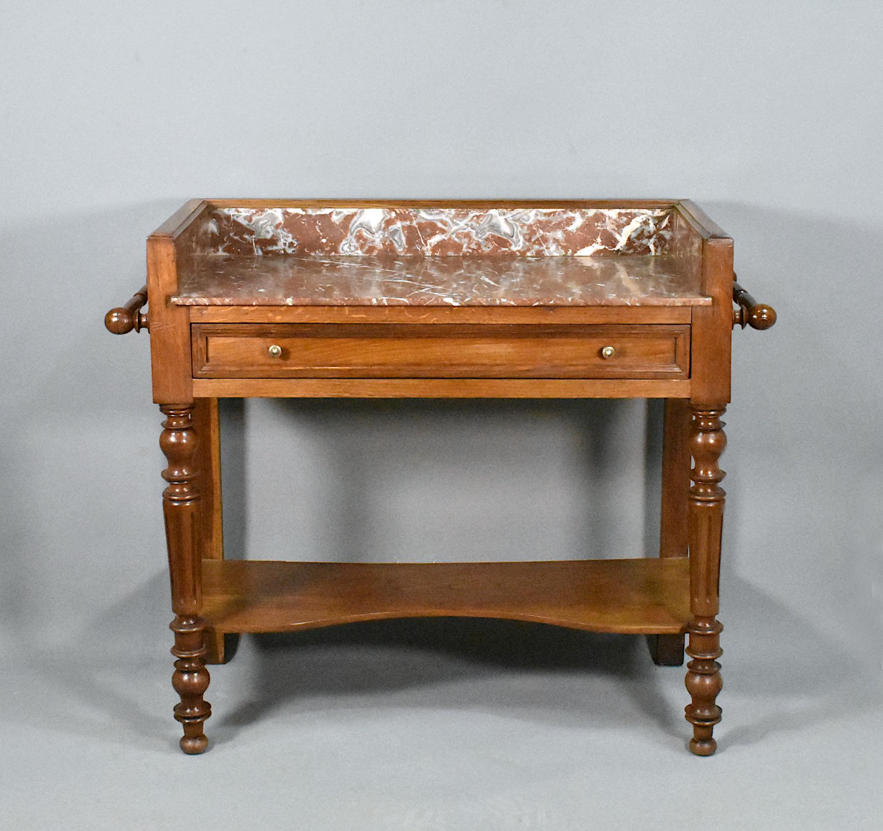 French antique Washstand in Oak Louis Philippe style 

This attractive solid oak washstand features a red and white variegated marble top and surround. 

Below the marble is a full-width drawer with a moulded front and silvered drawer pulls.