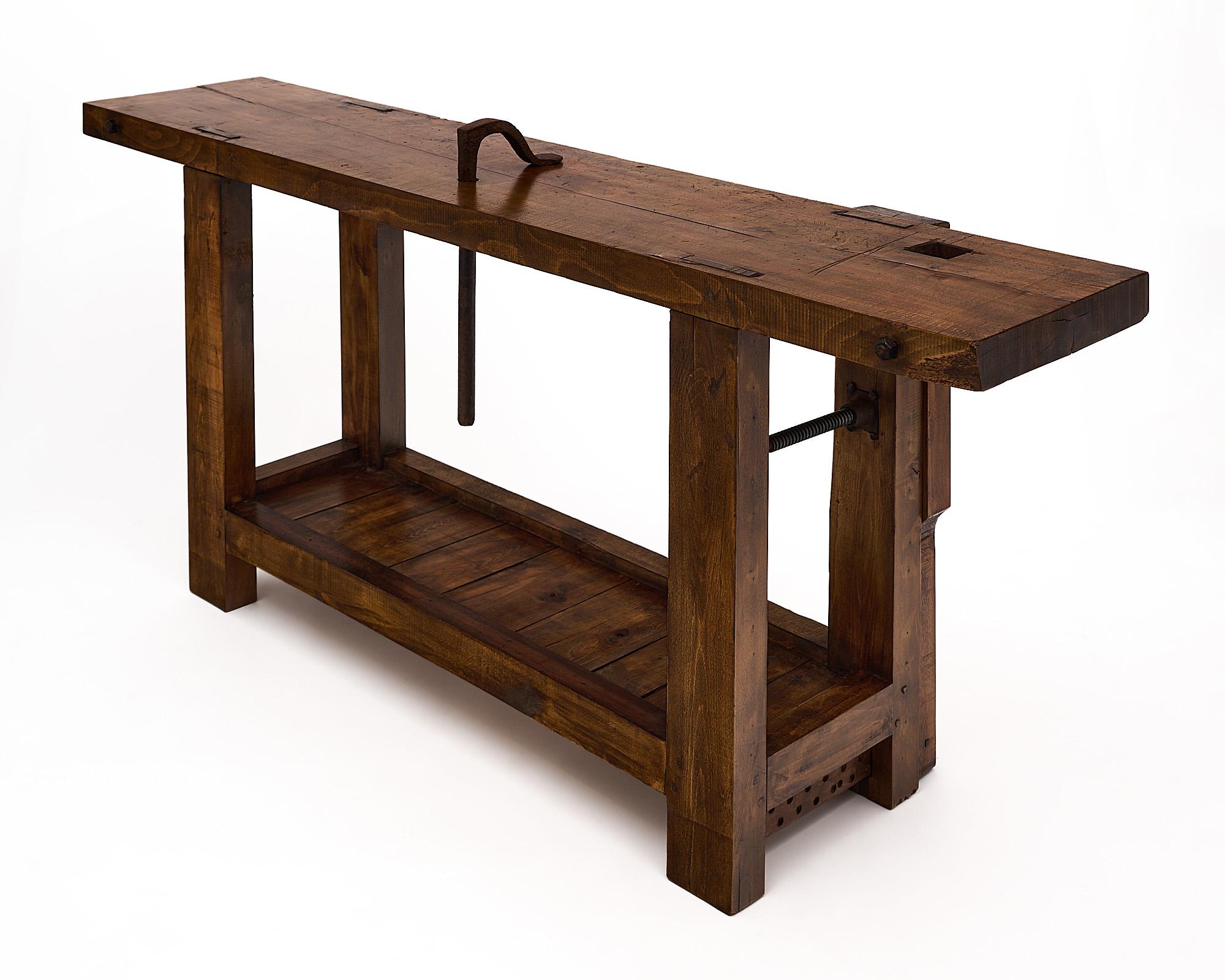 Workbench, French, made of beech wood. This was the essential wood in the craftsmen shops all throughout the 19th century. This console piece features the original vise, a forged iron clamp, and a bottom shelf. The depth of the table top is 15.5”.