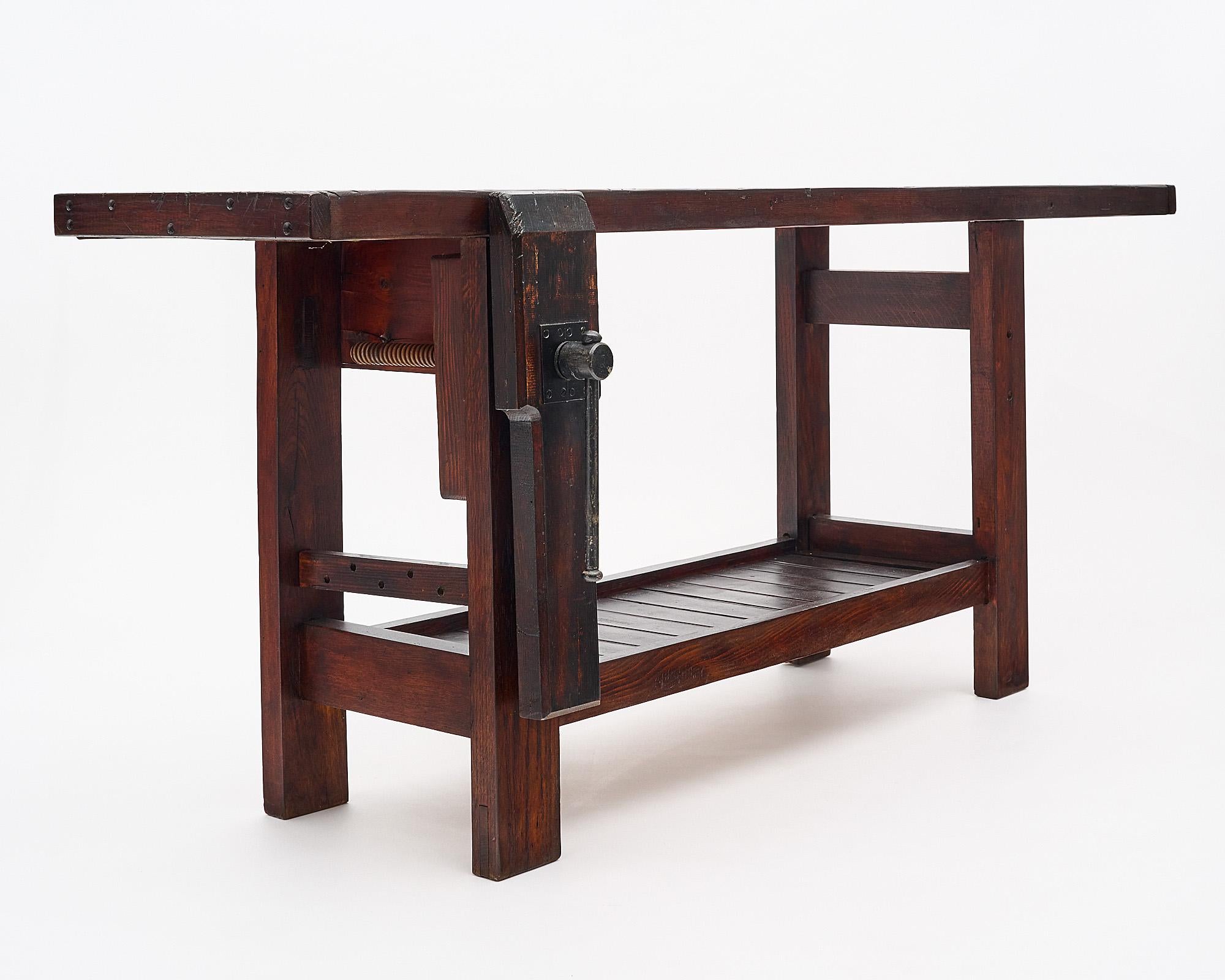 Workbench, French, made of stained and waxed wood. This piece features a shelf and the original vise. The depth listed includes the vise for a full depth, the depth of just the top is 18”.

