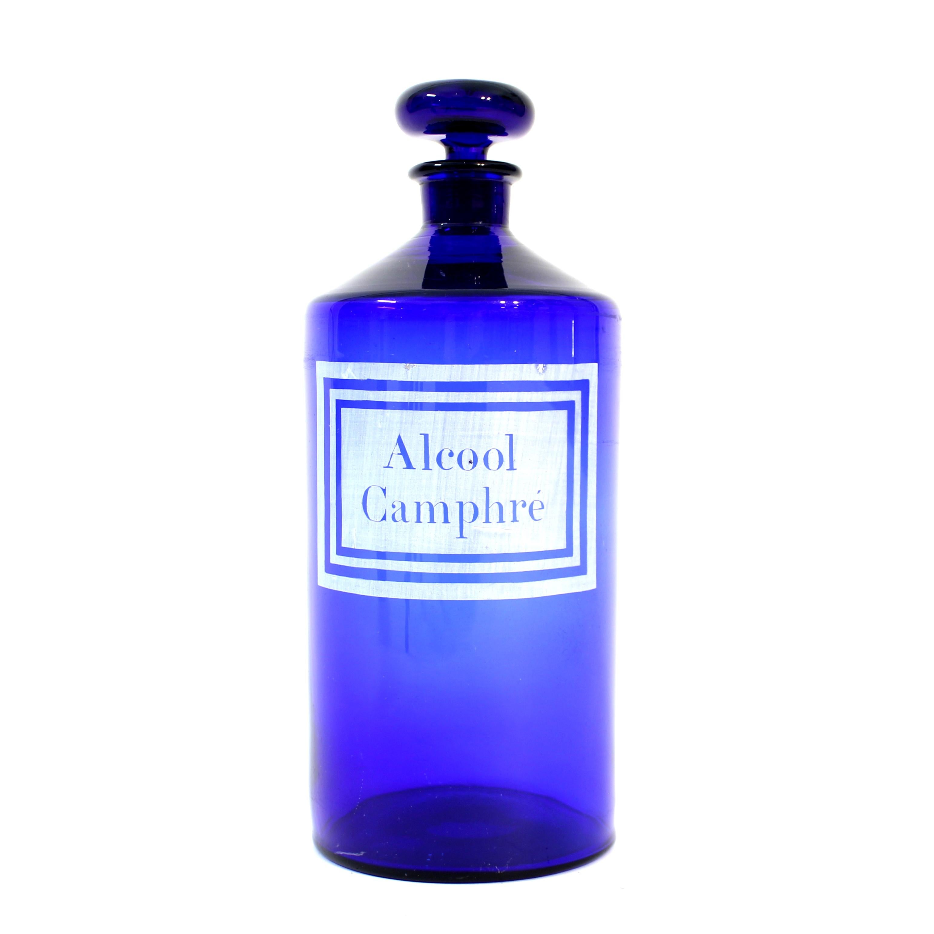 French apothecary bottle (or jar) with lid, in cobalt blue, from the first half of the 20th century, ca 1930. It has a white painted label that reads: 