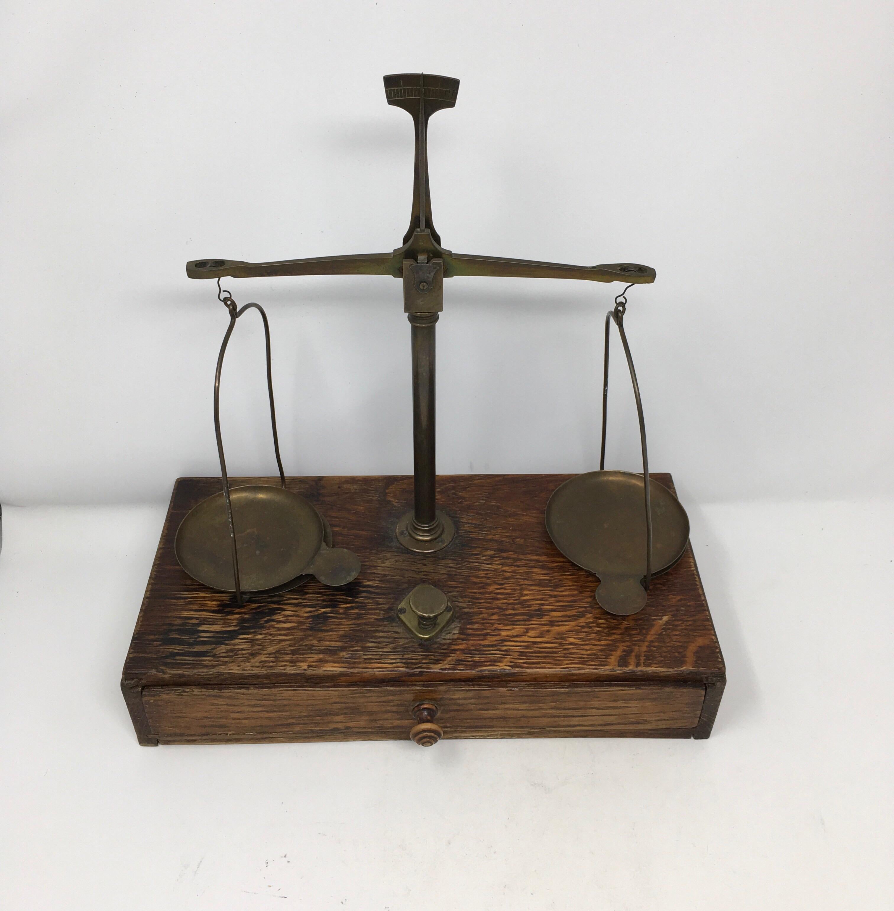 Found in Southern France, these brass and wood apothecary scales where used in French pharmacies throughout the country. The scales and weights are brass housed on a wooden base with a drawer. Although some of the weights are missing, these scales