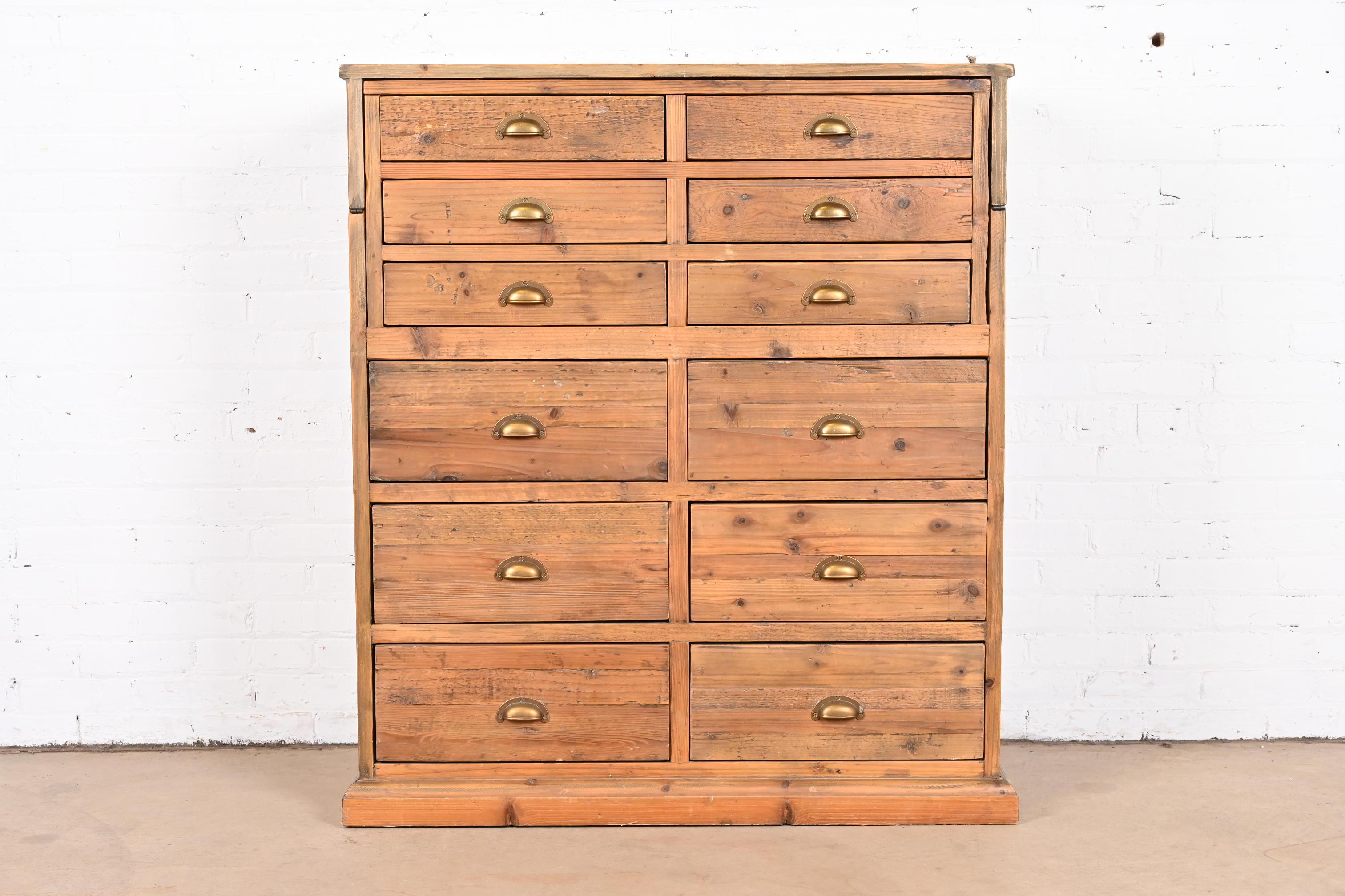 A fantastic 12-drawer file cabinet or apothecary cabinet with fold down desk or work station.

circa Late-20th century

Pine, with original brass hardware.

Measures: 41.25