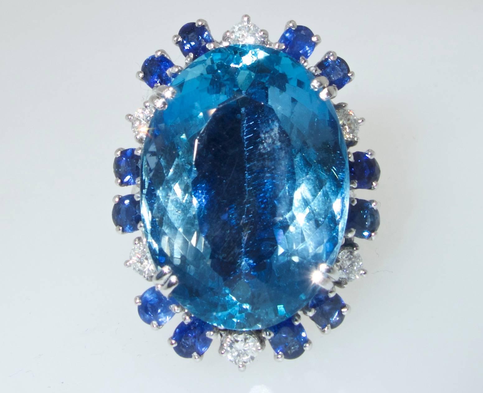 The fine natural blue Aquamarine weighs approximately 25 cts.  It is a fine clear deep  blue color.  Surrounding this center stone are 12 fine natural medium natural unheated and untreated blue sapphires.  The sapphire weigh is approximately 1.0