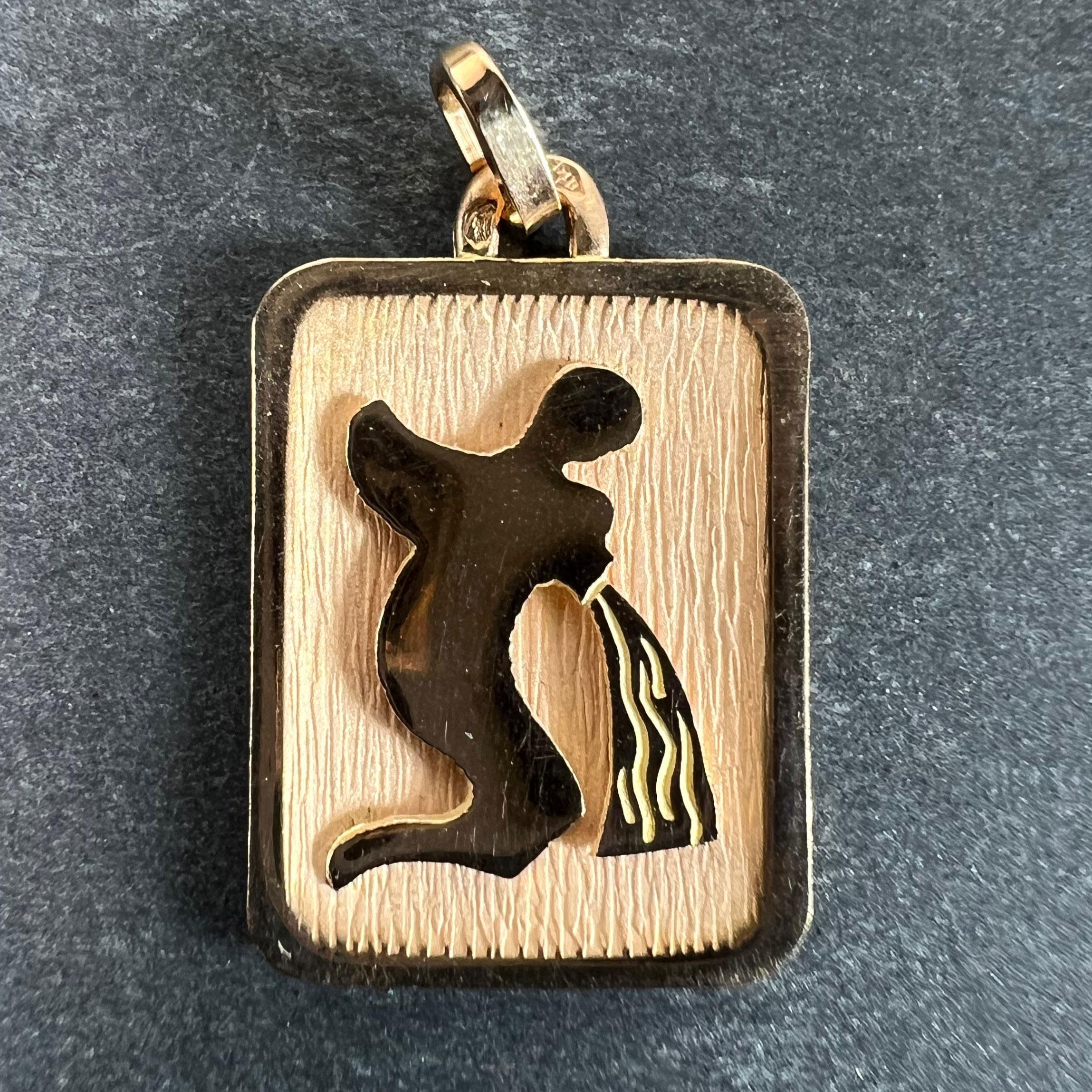 Pendentif à breloques en or jaune 18 carats (18K) conçu comme une médaille rectangulaire avec un renfoncement gravé représentant une personne versant de l'eau représentant le signe astrologique du zodiaque du Verseau. Estampillé de la tête d'aigle