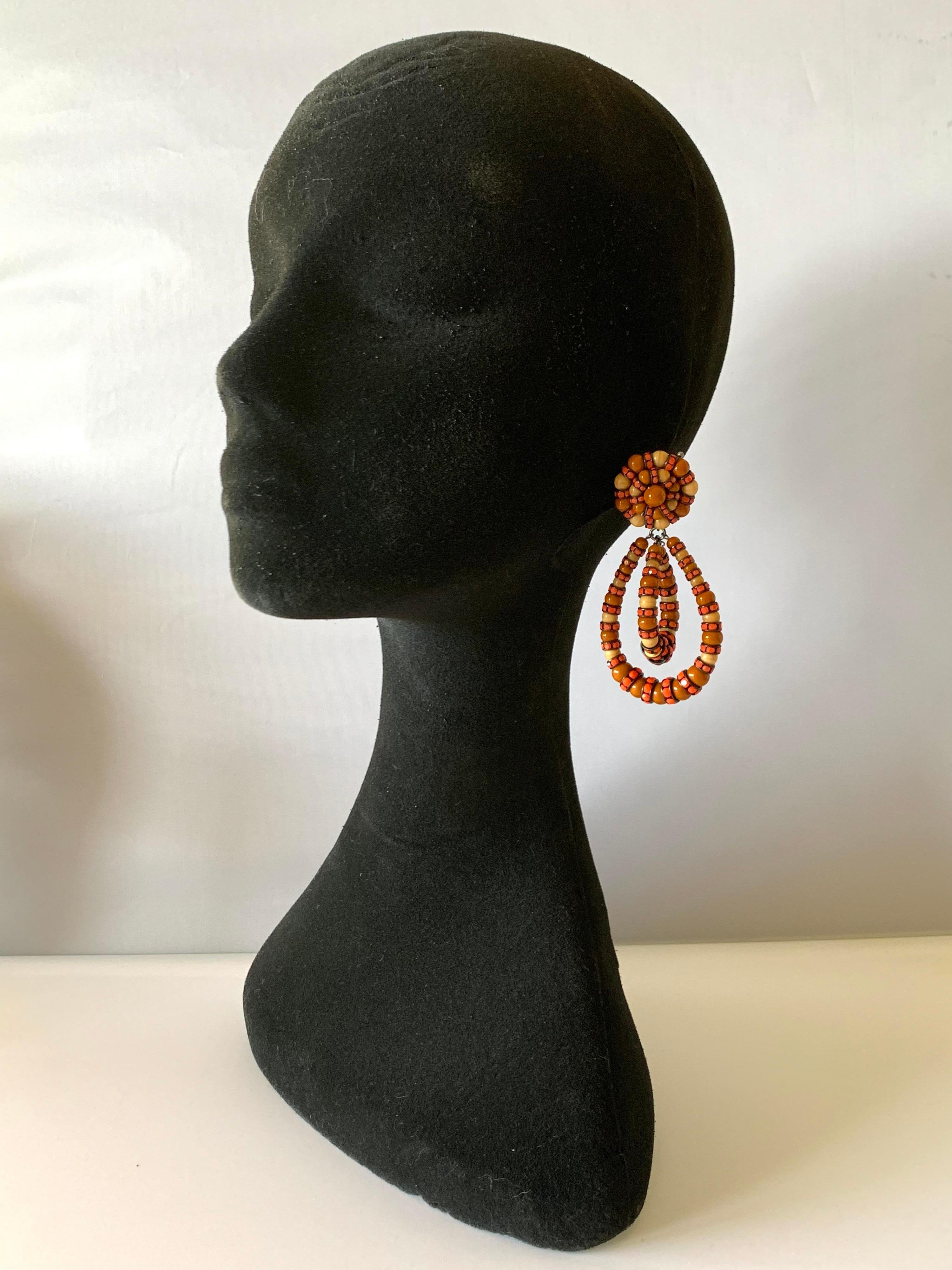 Twisted oval-shaped clip-on hoop statement earrings in warm pumpkin color - handmade glass cabochon and Swarovski crystal rondelles, made in Paris France.
