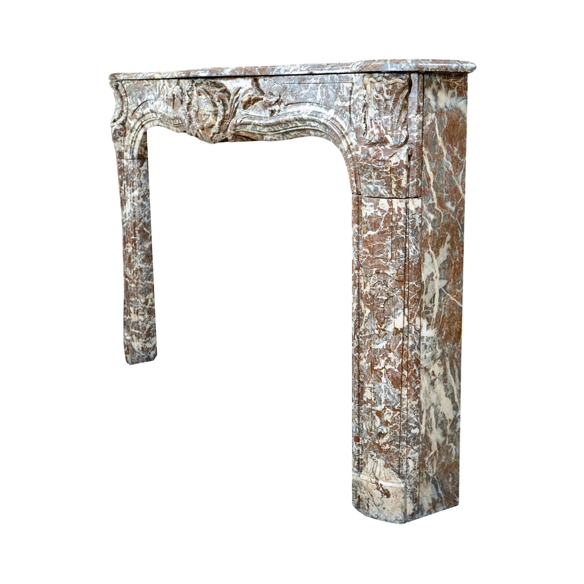 Expertly crafted in the 1820s, this French Ardennes Grey Marble Mantel exudes elegance and sophistication. Its Louis XVI design features a carved motif in the center and on the mantel legs, adding a touch of opulence to any room. Made from Ardennes