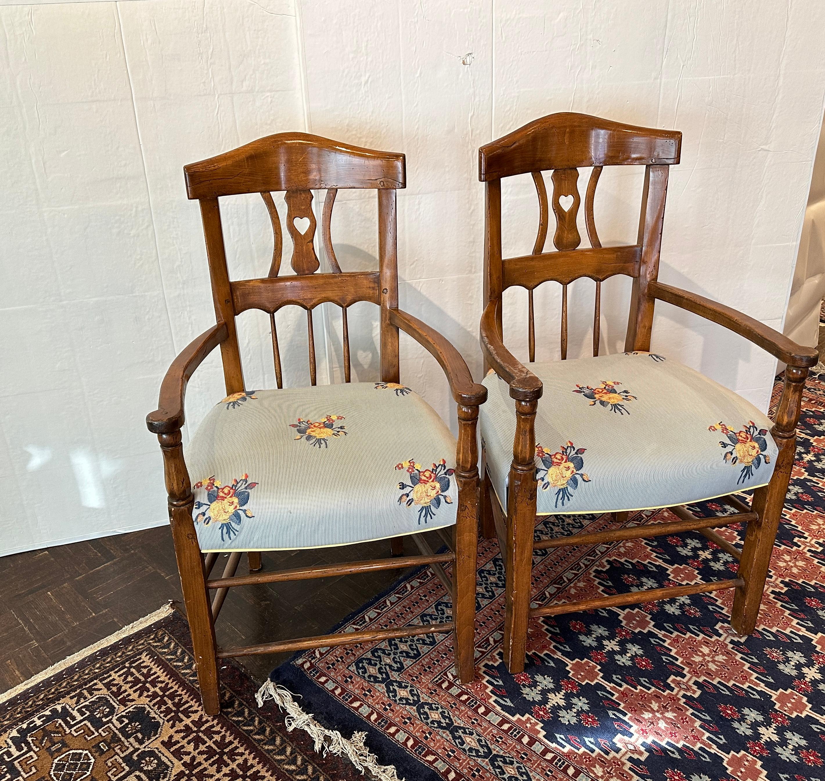 Set of four charming vintage arm chairs.  Each piece is hand made and hand antique finished feel.  Back is accented with small heart cut out.  Upholstered In beautiful silk strie flower fabric.  Newly recovered condition.
Very comfortable with
