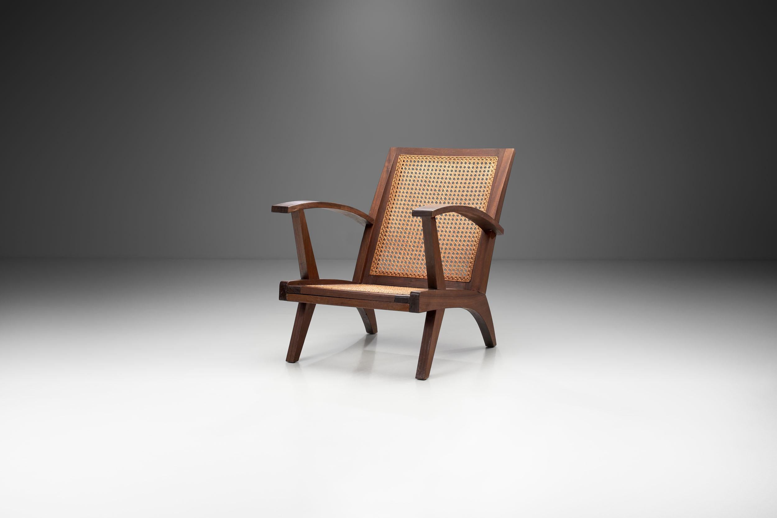 Ce fauteuil français du milieu du siècle combine un corps structurel visuellement étonnant avec une technique de cannage experte et des matériaux de haute qualité. De tous les côtés, les angles de cette chaise sont visuellement saisissants,