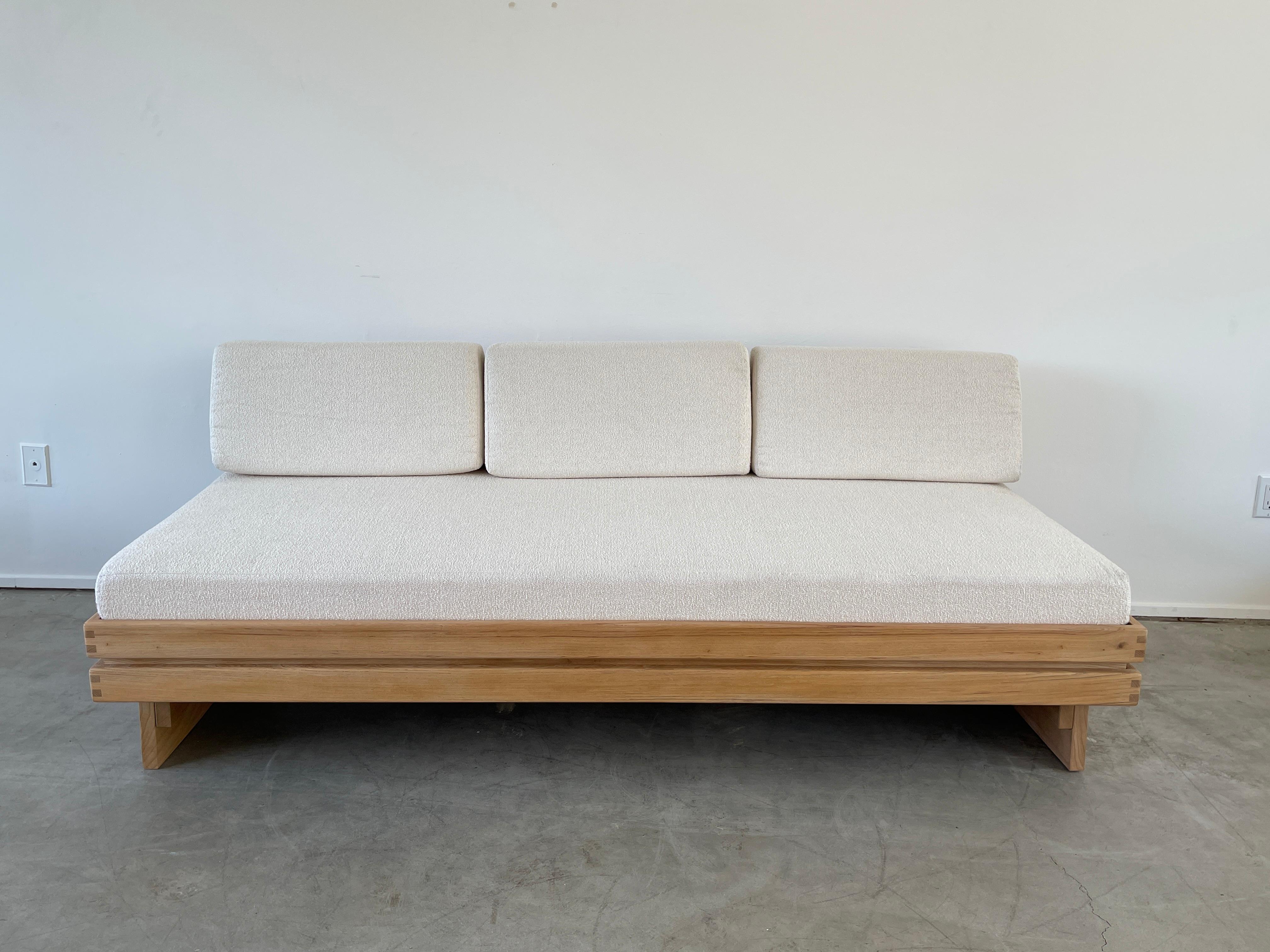 Large bench seat sofa produced in the 1980s by Maison Regain
Solid construction in elm wood reminiscent of Pierre Chapo. 
Beautiful grain to wood 
Newly upholstered seat and back cushion in a boucle from France. 

 