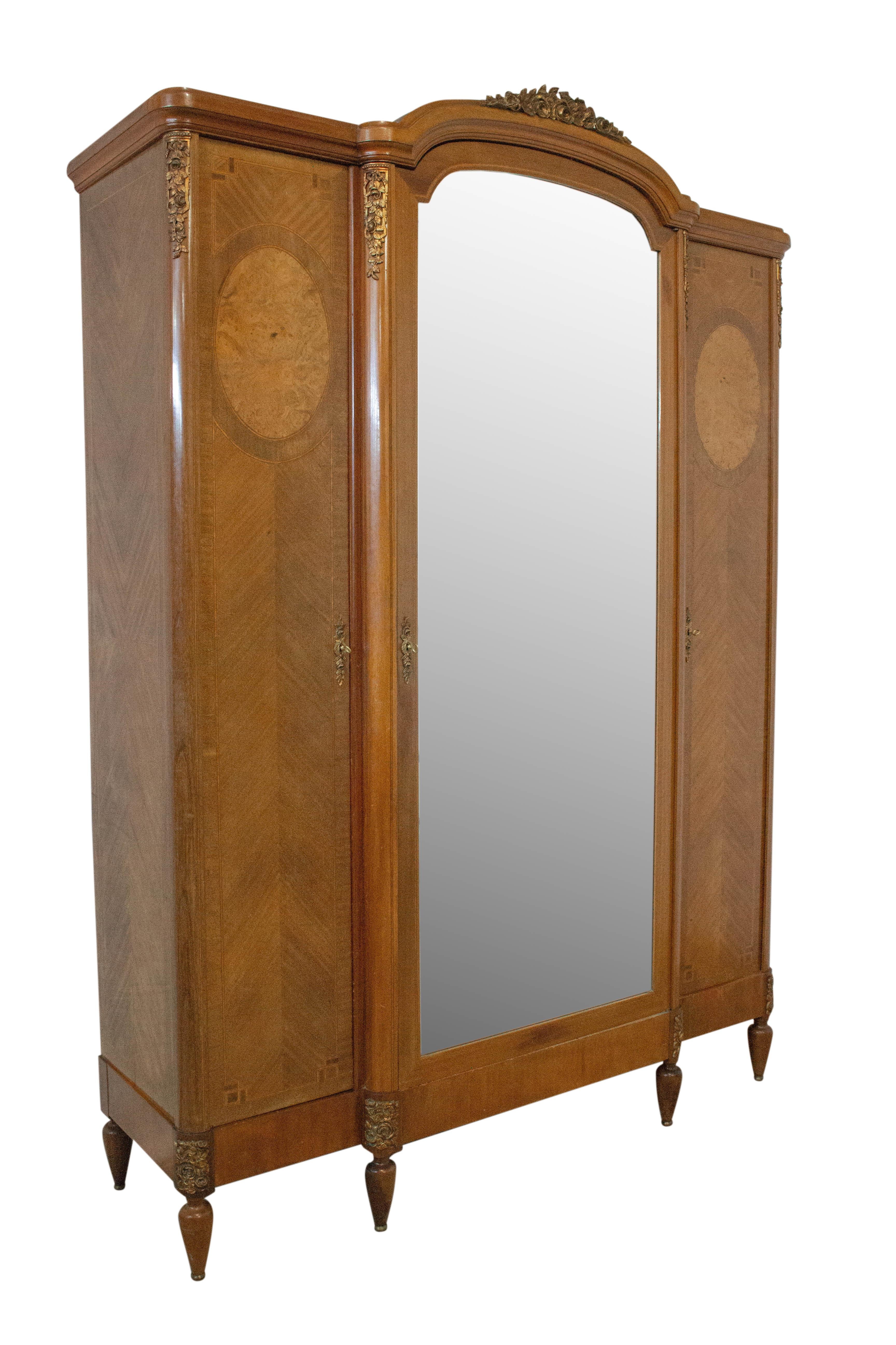 French mirror door wardrobe 1900 Louis XVI style, blond exotic wood and elm burl armoire
Marquetry work and bronze roses.
Cabinet with two drawers and three doors.
Few marks on the bottom of the armoire, please see photos.
In good antique condition