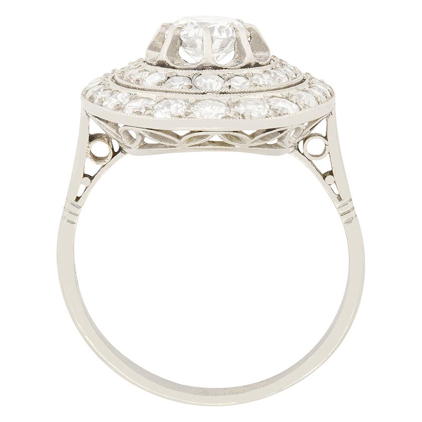 This engaging French 1920's diamond cluster ring is composed of two oval shaped halos surrounding one central old cut. The central diamond which is raised above the halos, weighs 0.65 carat and has been estimated as F in colour and VS2 in clarity.