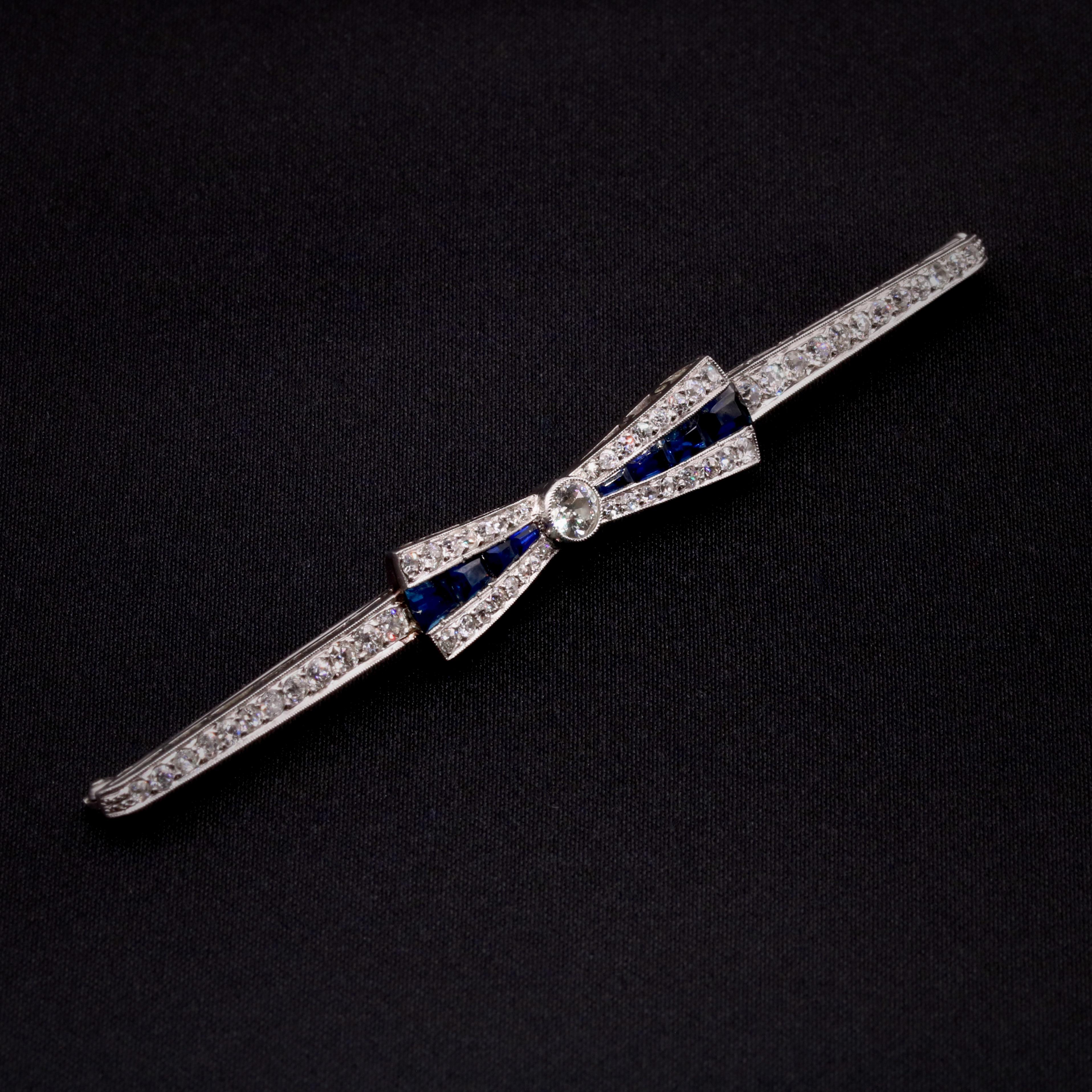 An Art Deco, sapphire, diamond, and platinum brooch, comprising eight calibre step cut blue sapphires, one large old European cut diamond, and fifty-six smaller old European and single cut diamonds, set in platinum, with platinum fittings and pin.