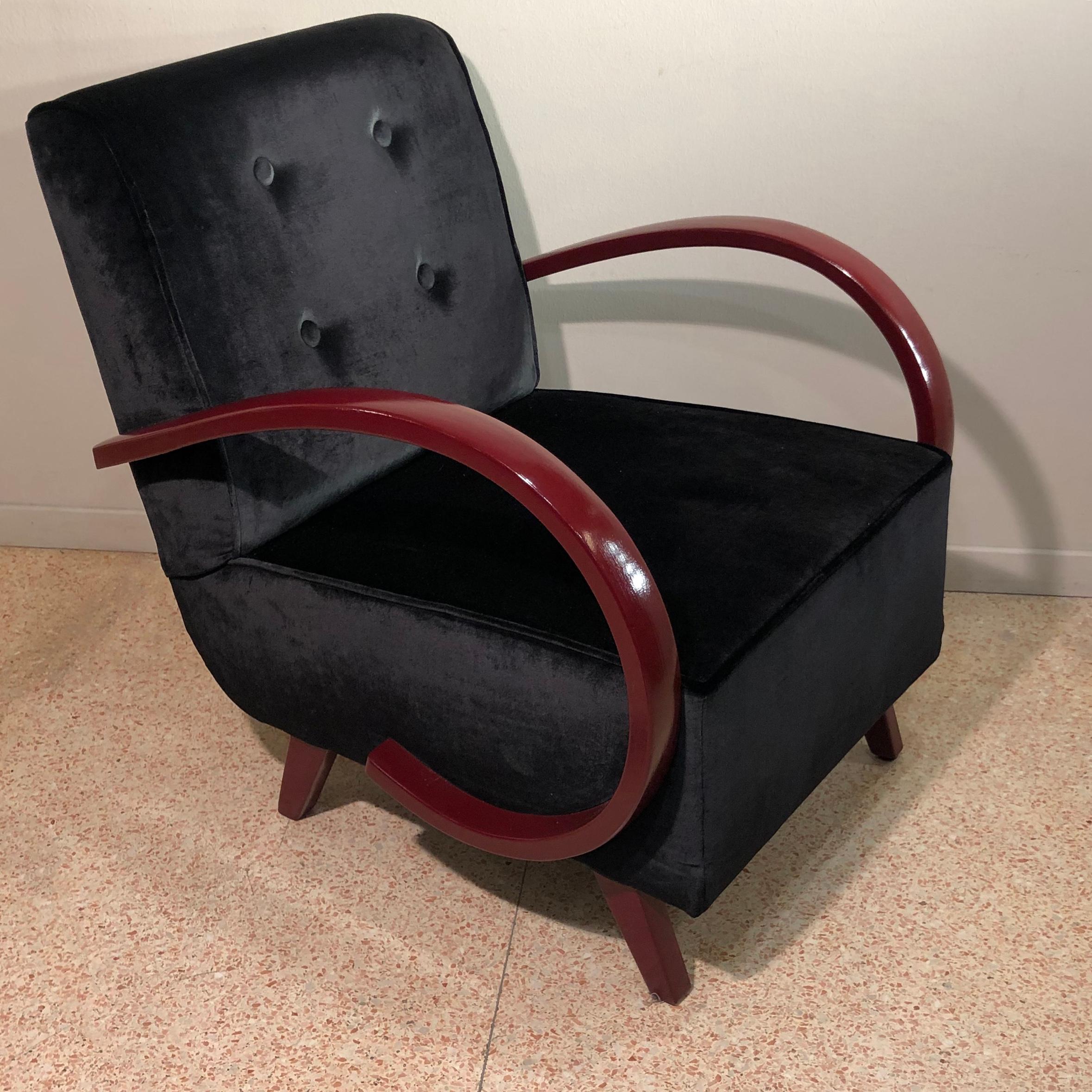 Pair of Art Deco armchairs from 1930s period. Black silk velvet and dark red wood lacquered armrests. Deep and large seat. Reupholstered and restored in a conservative way in the wooden parts. Since they are finely finished on the back with black