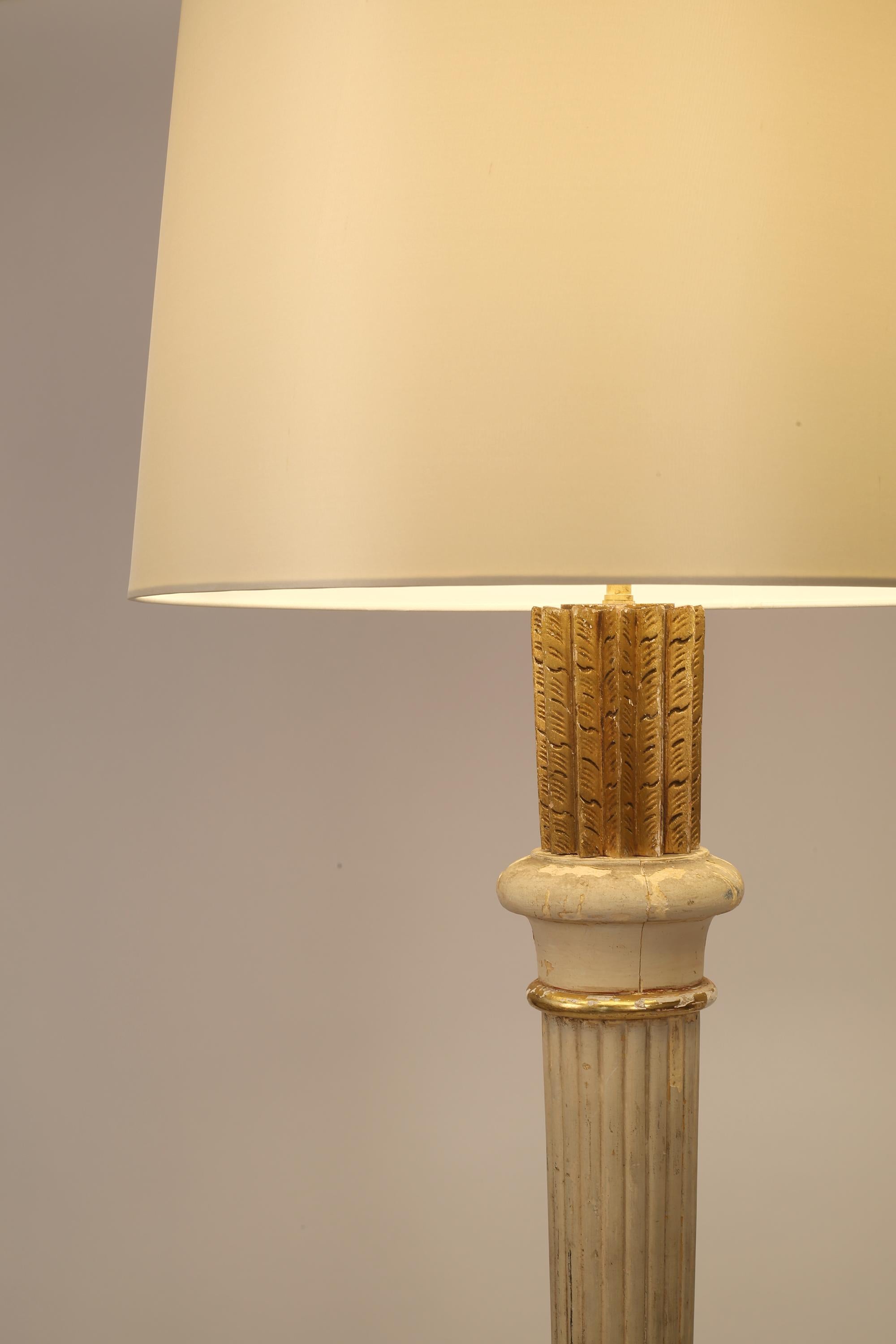 A chic and characterful Art Deco floor lamp attributed to Masion Dominique. Constructed from turned and carved timber, lacquered and decorated in gilt gesso - now heavily patinated. The finial of the lamp stylised as a quiver of arrows, above a