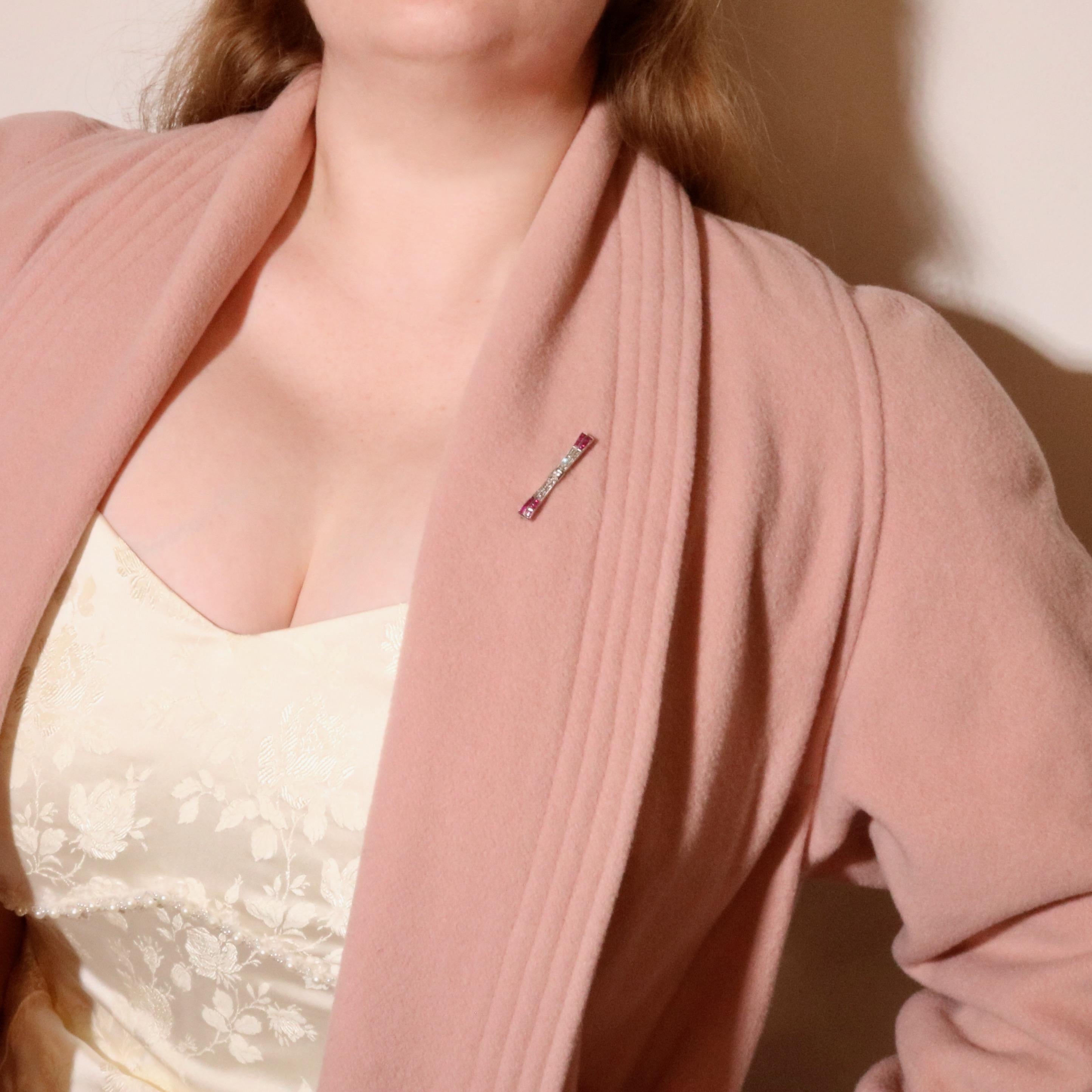 An Art Deco platinum, diamond, and ruby brooch, comprising one larger transitional cut diamond, thirty-two rose cut diamonds, and twelve baguette cut rubies, set in platinum, with platinum pin and fittings. 

This brooch is designed as a stylised