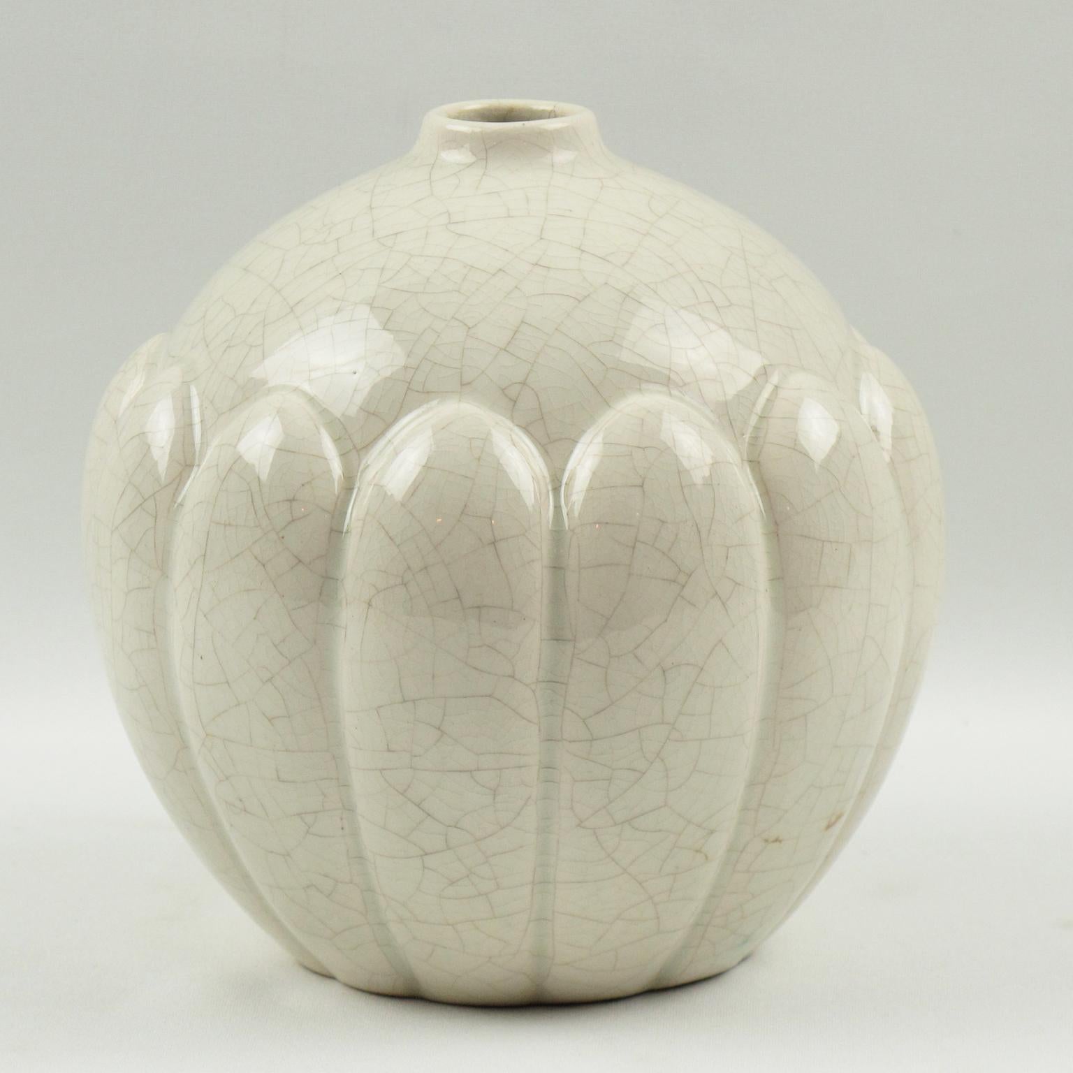 Joli vase Art Déco de Saint Clément, France. Vase en céramique française avec une finition de glaçure craquelée blanche. Il présente une forme ronde et bouffante avec une petite ouverture au niveau du col et une sculpture stylisée détaillée avec une