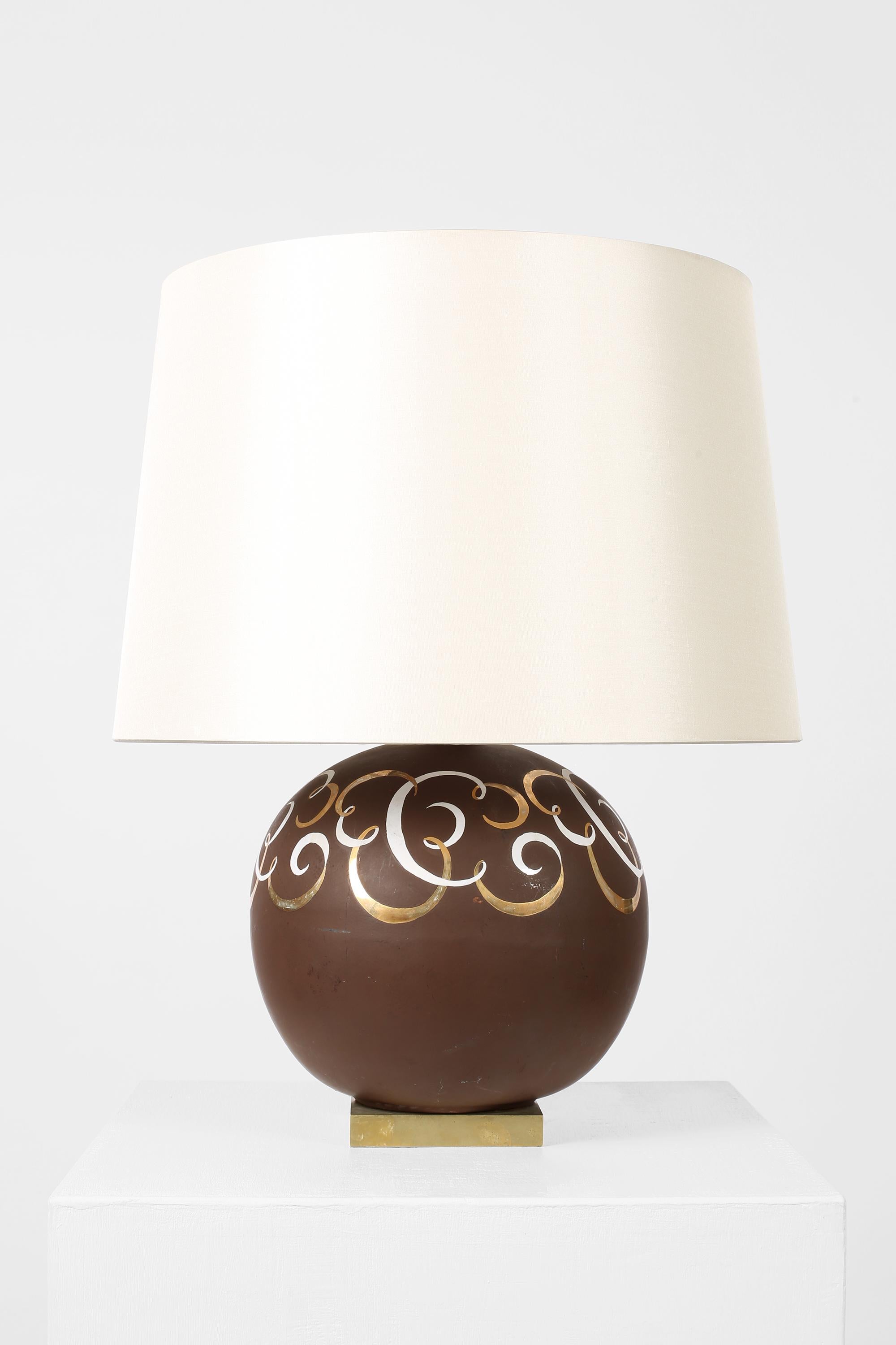 Eine schicke Terrakotta-Boule-Lampe im Art-Déco-Stil mit schokoladenbrauner Glasur und dekorativem, verschnörkeltem, emailliertem Design in Weiß und Gold. Auf einem kubischen Sockel aus patinierter Bronze stehend.

Französisch, ca. 1940er Jahre.