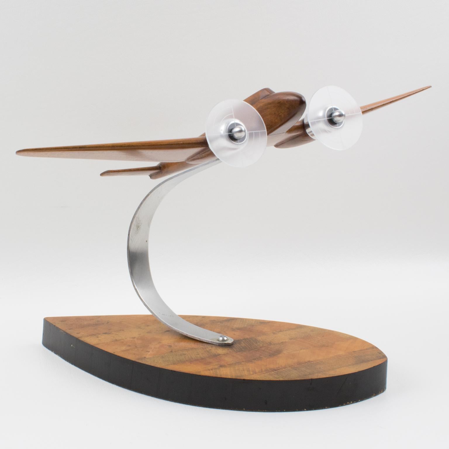 Handsome French Art Deco wood and aluminum airplane model mounted on a stylized wood plinth. This nice 1940s model airplane is made with varnish wood and aluminum and Lucite for the two propellers. Standing on a geometric wood plinth with an