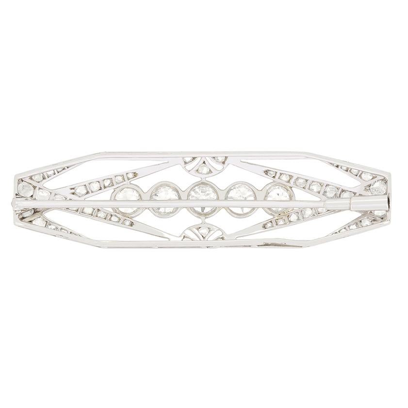 This stunning French diamond brooch showcases the Art Deco style of the 1920s. The centre features five rub-over set diamonds, with a trio of 0.50 carat diamonds in the middle and 0.40 carat diamonds at either end. The intricate metalwork is