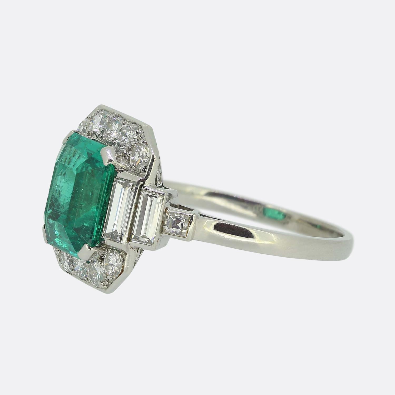 Here we have an outstanding ring crafted in France at a time when the Art Deco style was continuing to revolutionise the world design. This platinum piece features single emerald cut emerald of Colombian origin at the centre of the face. This