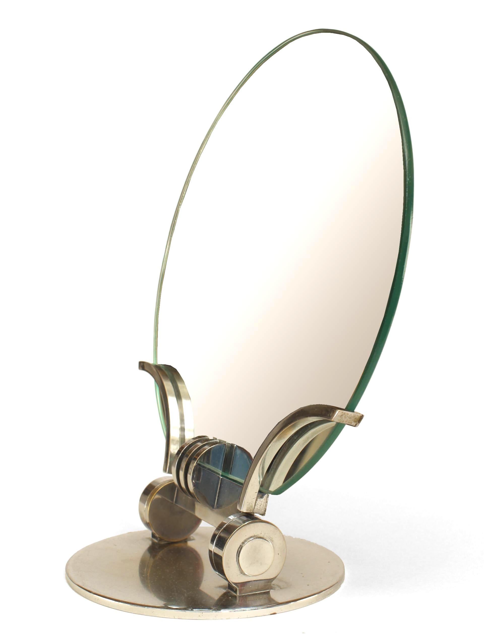 French Art Deco chrome plated dressing table mirror characterized by a piece of round, frameless mirrored glass positioned above a smaller round chrome base with a stylish adjustable stand composed of the same material.