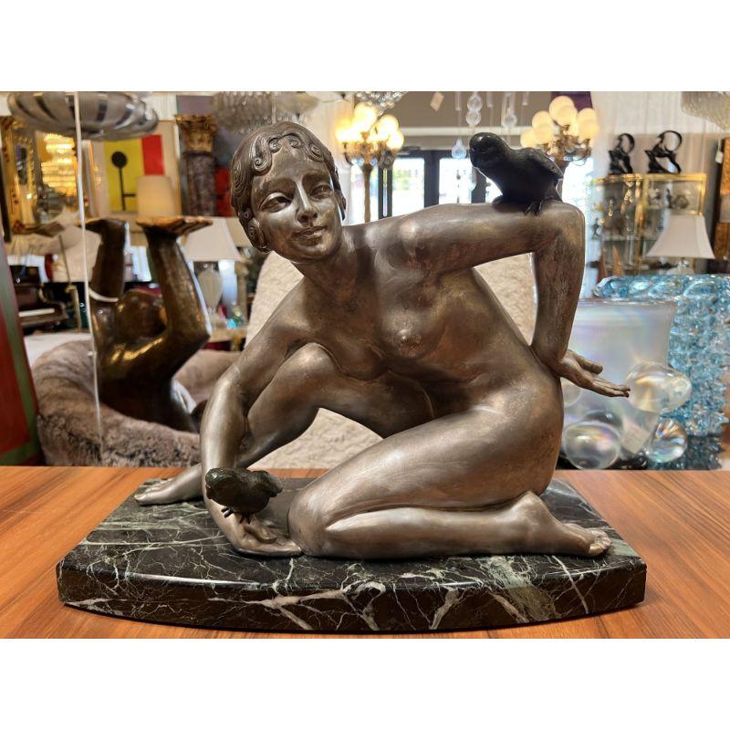 An amazing Art Deco silvered bronze sculpture of a female nude holding two parrots. Mounted on a black and green marble piece. Signed on back side.