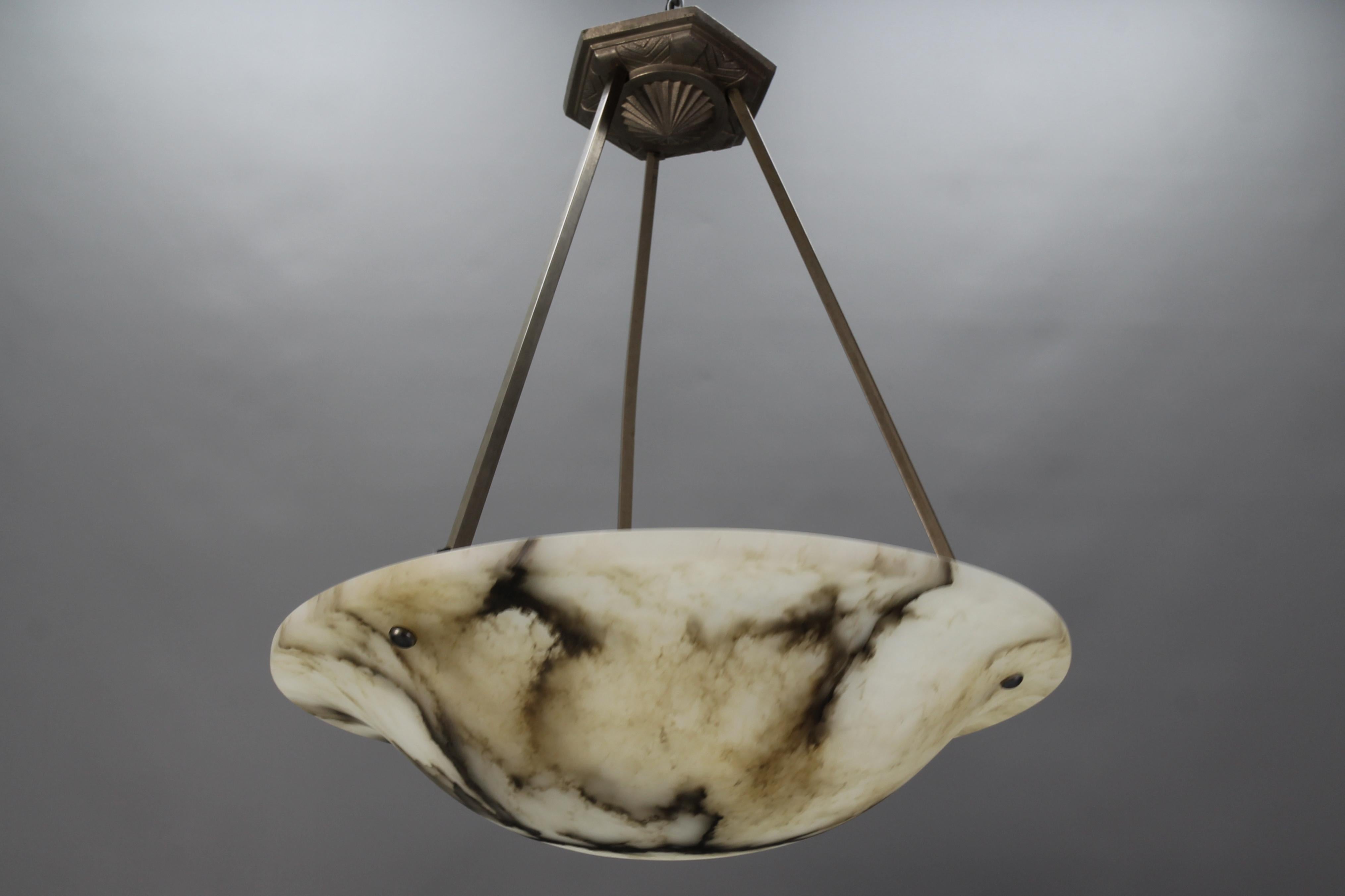 Art Deco white and black veined alabaster pendant light fixture.
A wonderful alabaster pendant ceiling light fixture from circa the 1930s. Beautifully veined one-piece white alabaster bowl suspended by the chromed brass fixture and a decorative