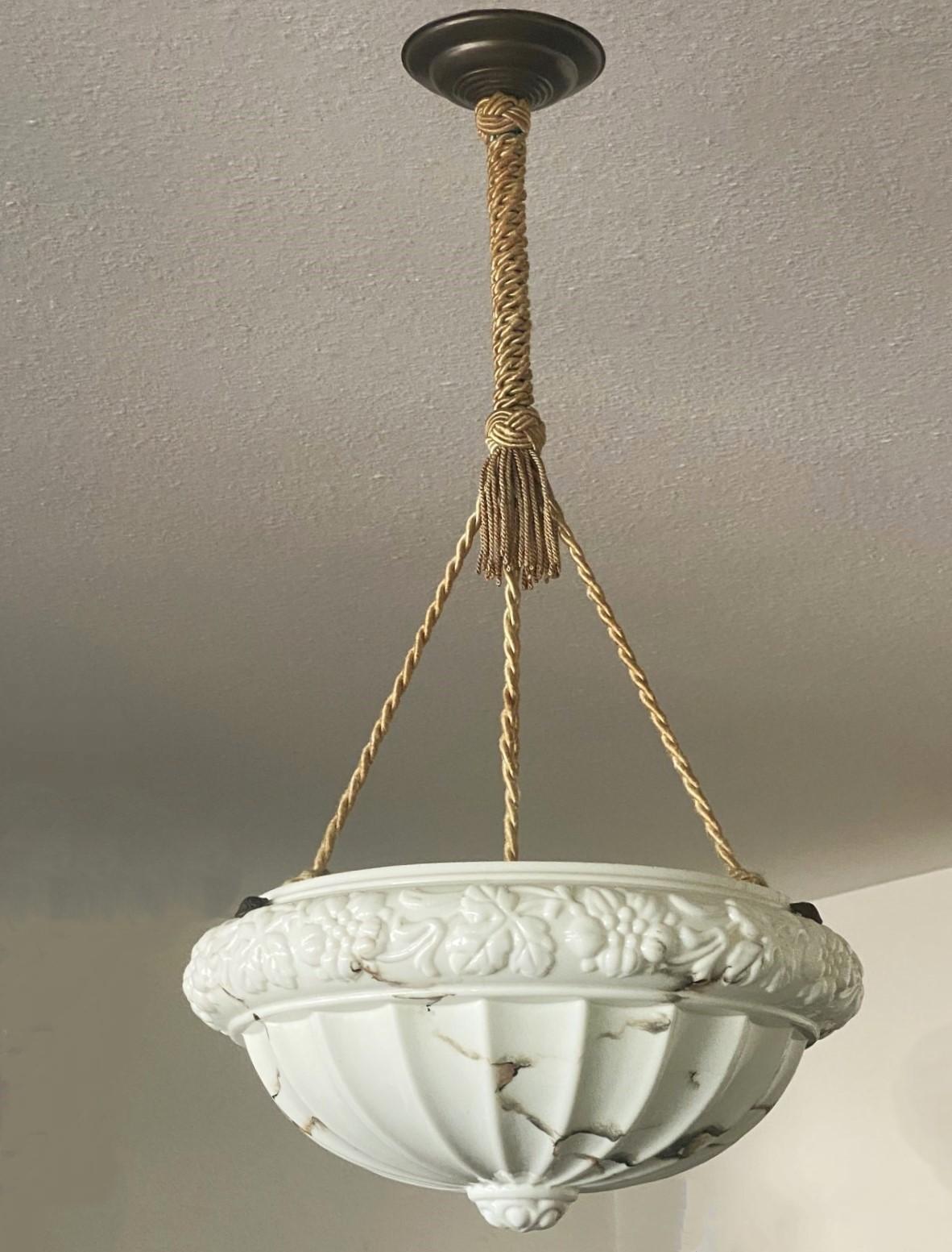 Art Deco high-releaf marbled glass pendant or lantern, France, circa 1920-1930. Art glass with a high relief rim with vine leaf motifs in shape of carved alabaster with beautiful black veins, suspended from three original hand-knotted silk ropes