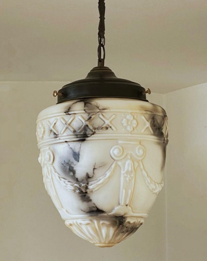 Art Deco high-releaf marbled glass light pendant, France, circa 1920-1930. Glass in carved alabaster looking with beautiful black veins. The glass shade is shaped like an antique greek crater with a patinated brass shade holder suspended by a