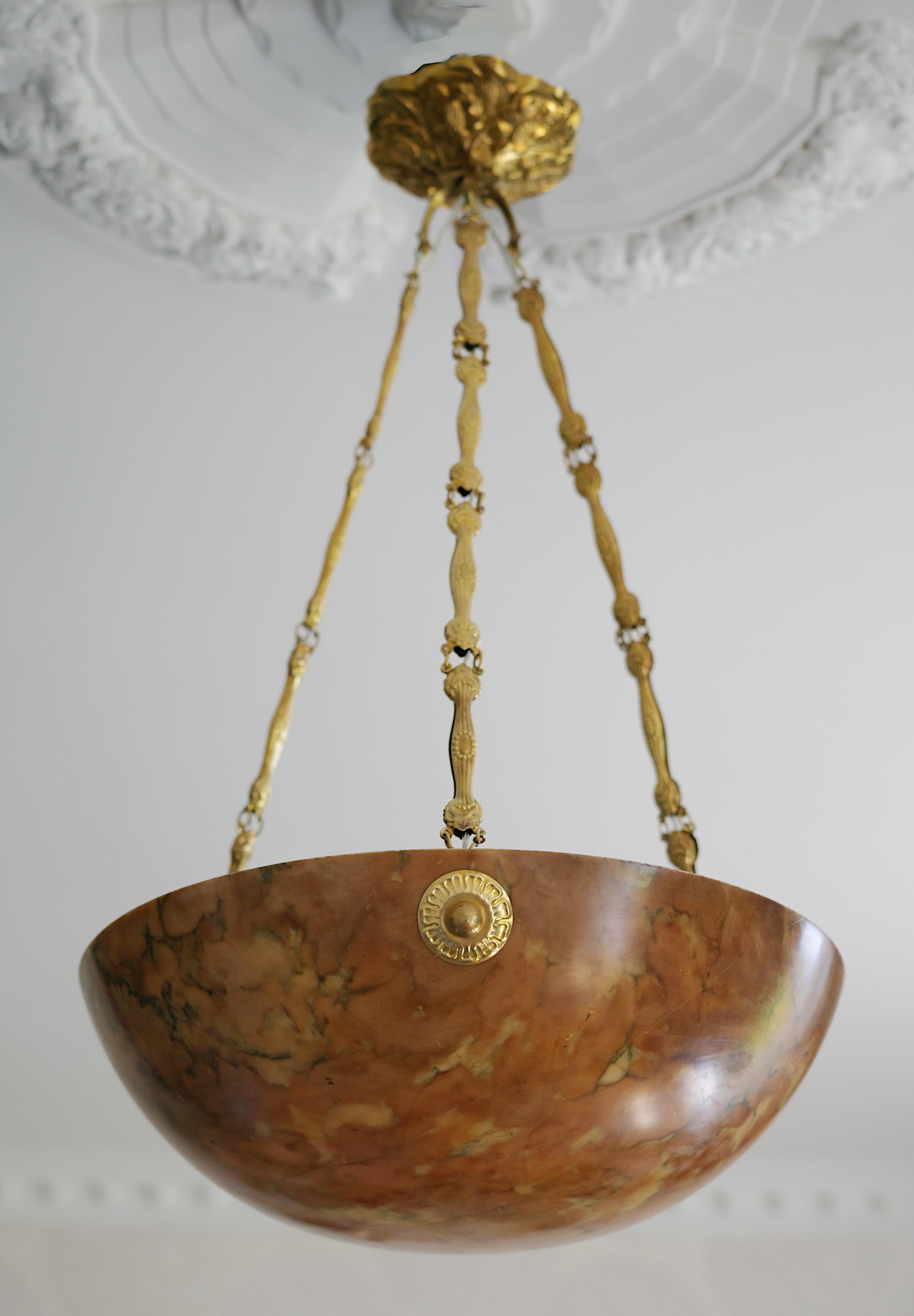 French Art Deco alabaster pendant chandelier, France, ca.1920. Thick alabaster shade hung at its stamped brass fixture. Old alabaster cannot be compared to new ones. Old alabaster has veins. Sometimes they can be mistaken for cracks. But they are