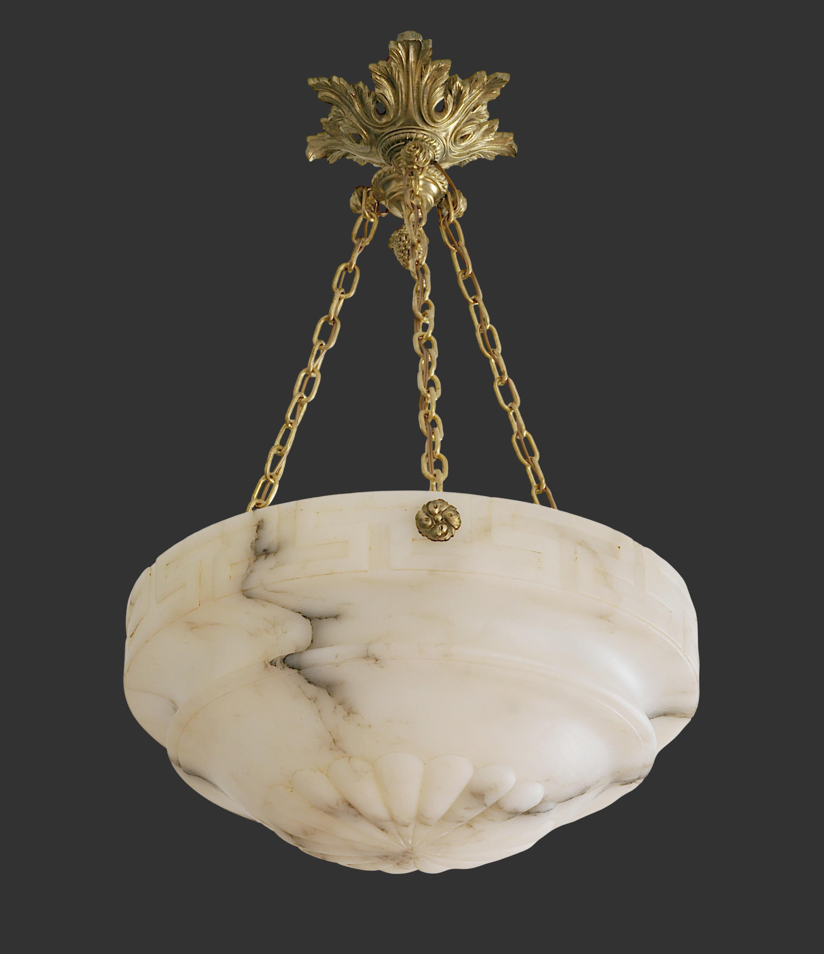 French Art Deco alabaster pendant chandelier, France, 1920s. Beautiful carved alabaster shade decorated with a central rosette in its lower part and a geometric belt in its upper part, separated by a deep circular groove. Old alabaster cannot be