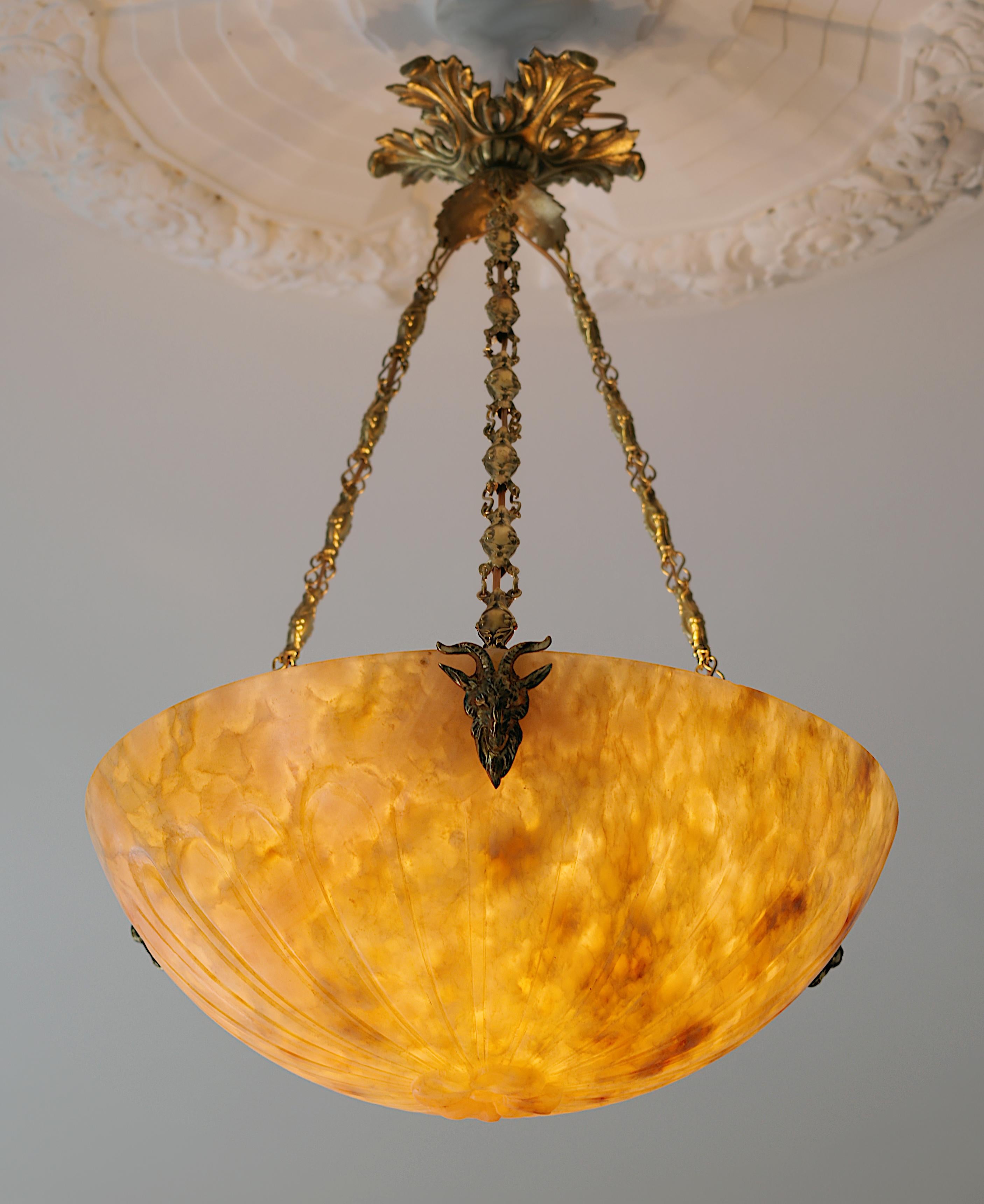 French Art Deco alabaster pendant chandelier, France, 1920s. Carved alabaster shade. Bronze (canopy and hidden-holes) and brass (chains) fixture. Goat's head hidden-holes. Old alabaster cannot be compared to new ones. Old alabaster has veins.