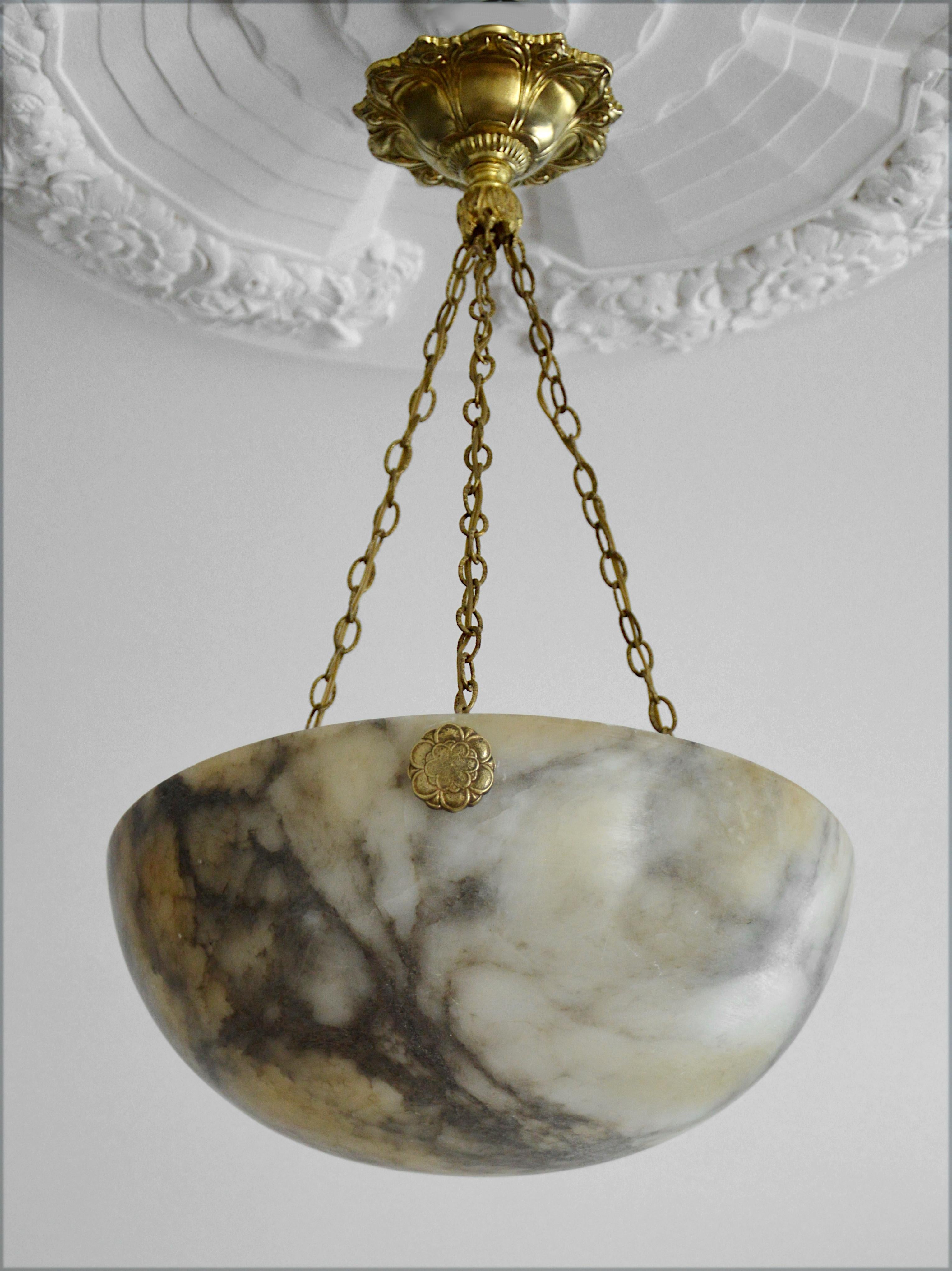 French Art Deco alabaster pendant chandelier, France, circa 1925. Alabaster, brass and bronze. Alabaster shade hung on its brass (canopy and chains) and bronze (hidden-holes) fixture. Old alabaster cannot be compared to new ones. Old alabaster has