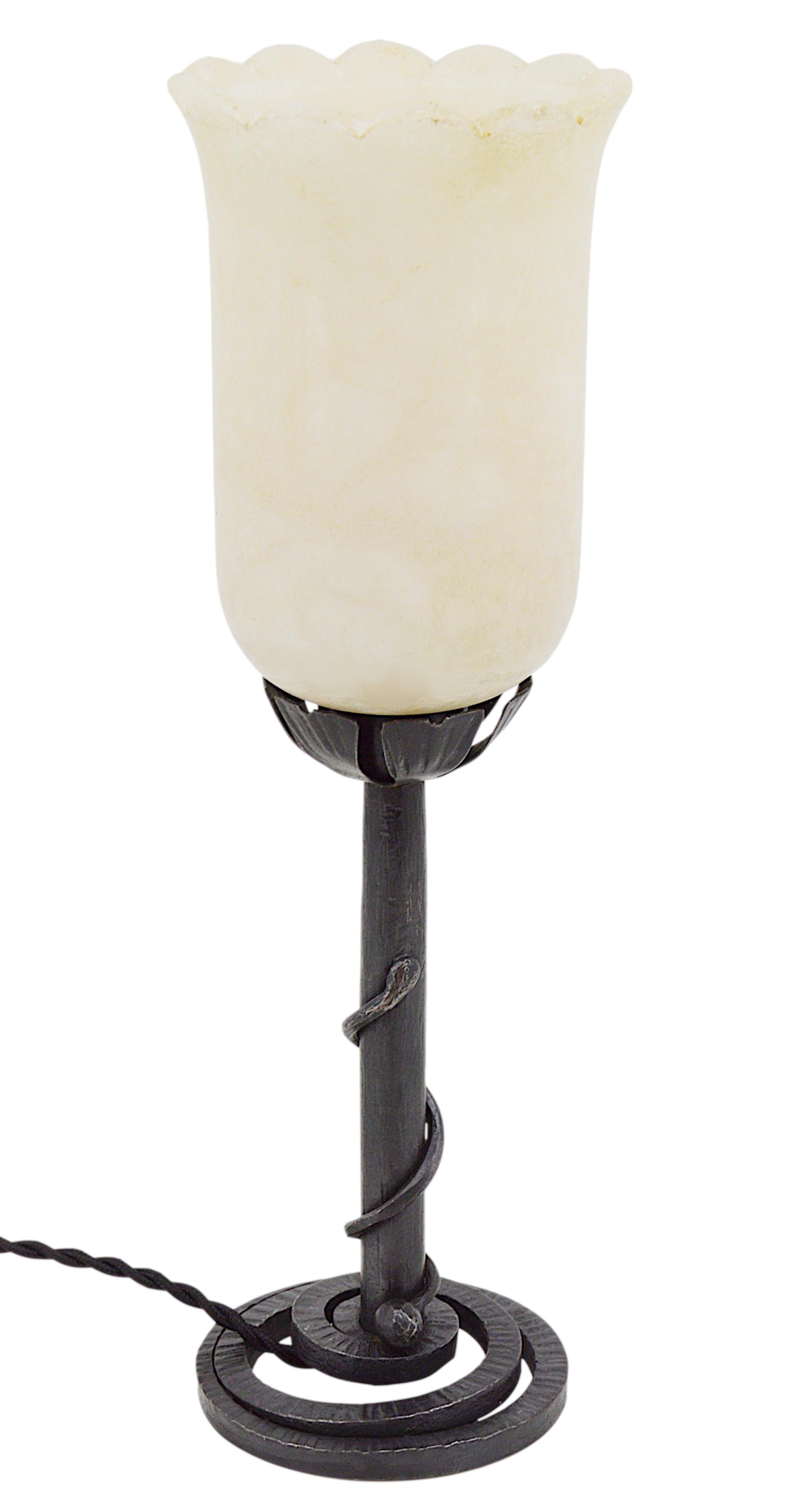 Französische Art-Déco-Tischlampe, Frankreich, 1920er Jahre. Stilvoller modernistischer Alabasterschirm auf einem schmiedeeisernen Sockel, der eine Schlange symbolisiert. Der Sockel ist mit 