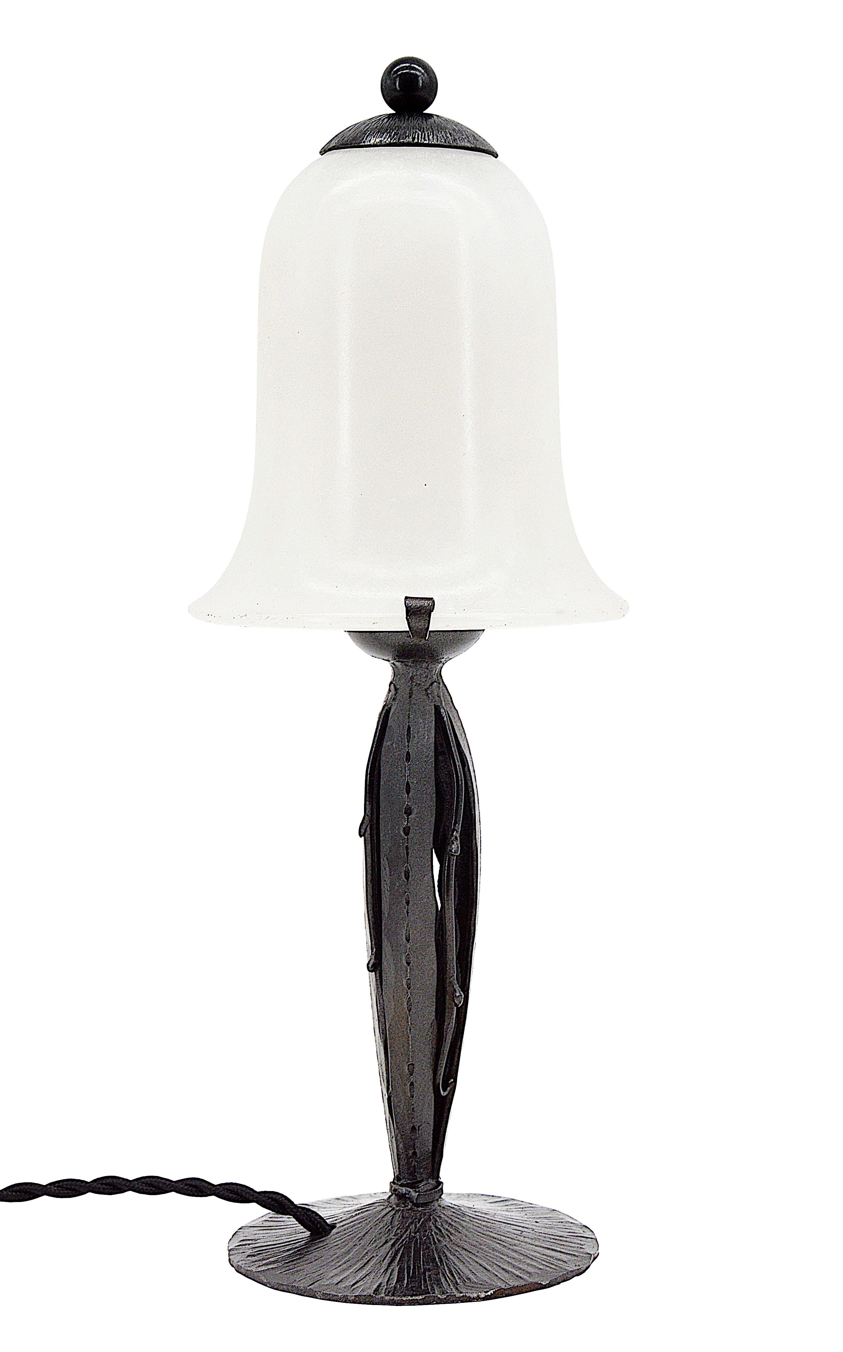 Cette lampe de table Art déco française des années 1920 présente une base en fer forgé remarquable et un élégant abat-jour en albâtre, alliant le design classique de l'Art déco à la beauté fonctionnelle. Sa hauteur de 12,3 pouces (31,3 cm) et son