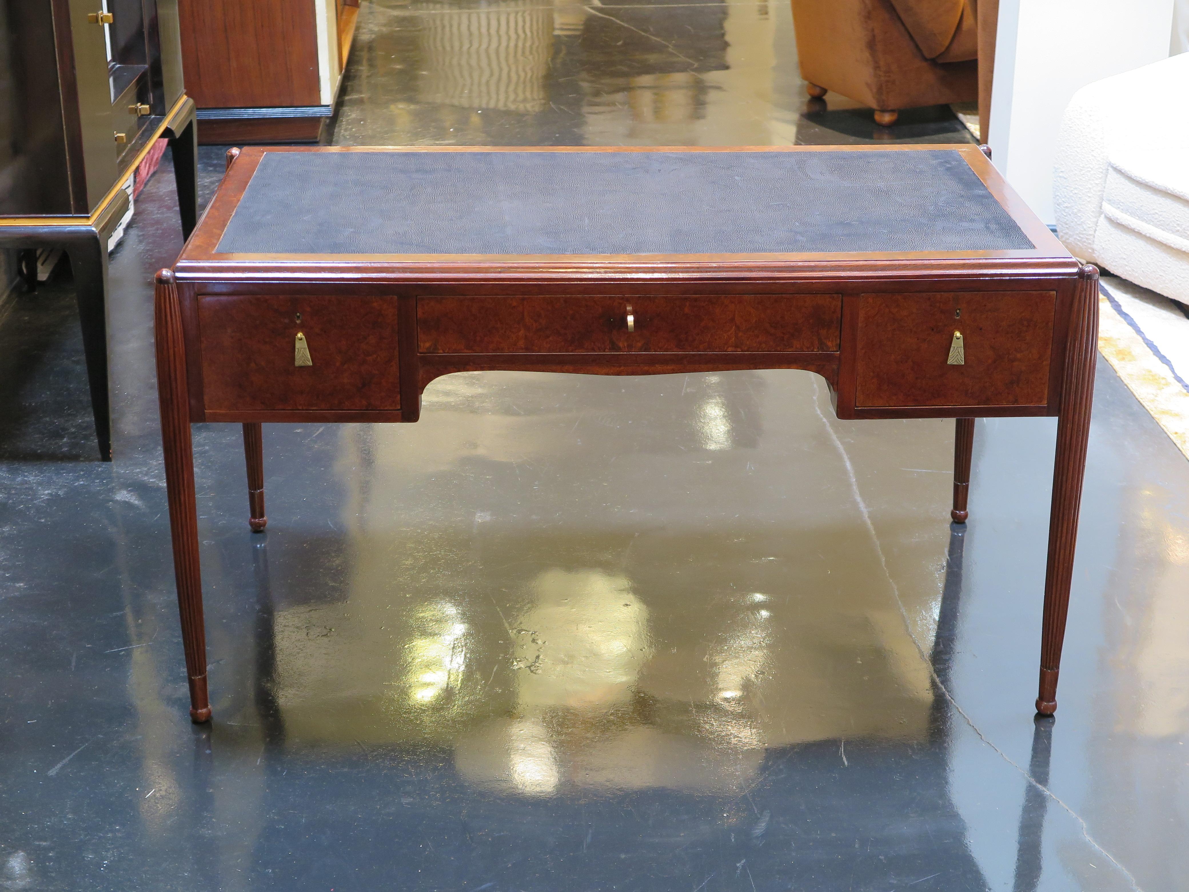 Rechteckiger französischer Art-Déco-Schreibtisch mit Rahmen aus Amboyna-Maser in Hochglanzausführung. Dieser Schreibtisch verfügt über zwei seitliche Schubladen und eine mittlere Schublade mit Basrelief-Schubladengriffen und Schlössern aus antikem