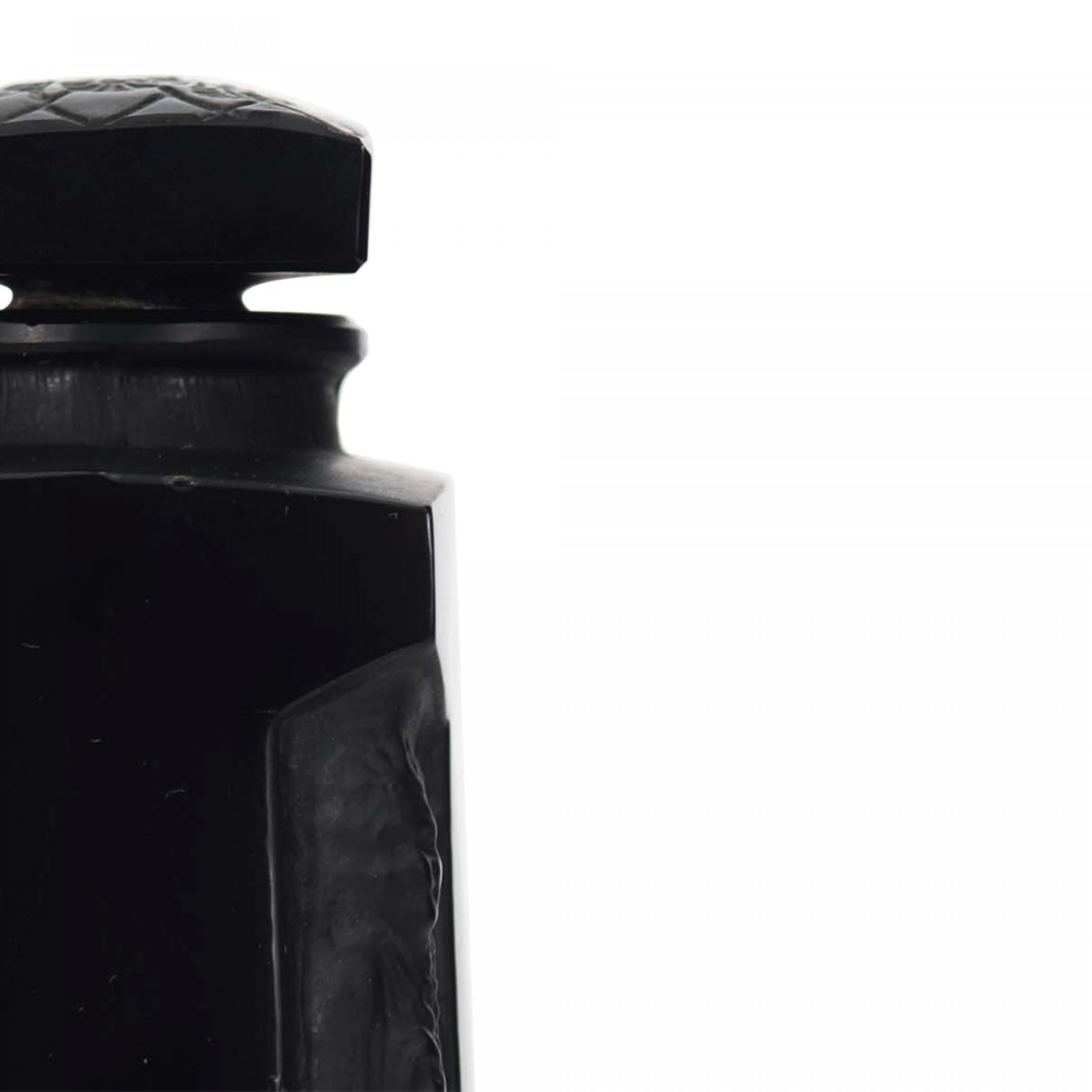 Bottiglia di profumo in vetro nero di Art Decor (AMBRE D'ORSAY by D'ORSAY) decorata con figure di donne vestite incassate ai quattro angoli, sotto un tappo quadrato con fiori dentellati (firmata Lalique).