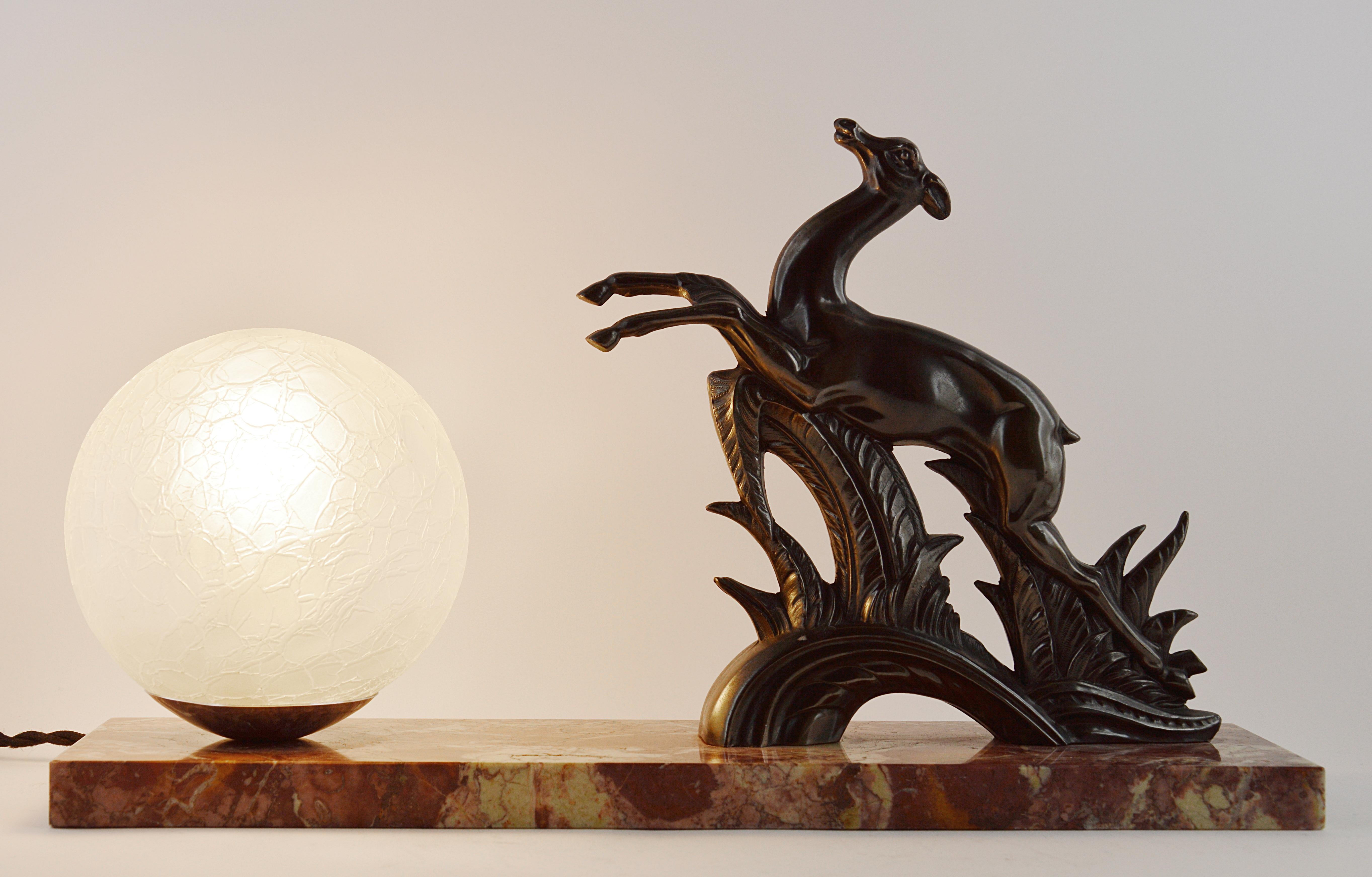 French Art Deco antelope table lamp, 1930s. Spelter antelope with its fishnet ball lampshade on its marble base. Original bronze patina. Delivered wired for your country (US, EU, Australia, etc.).
