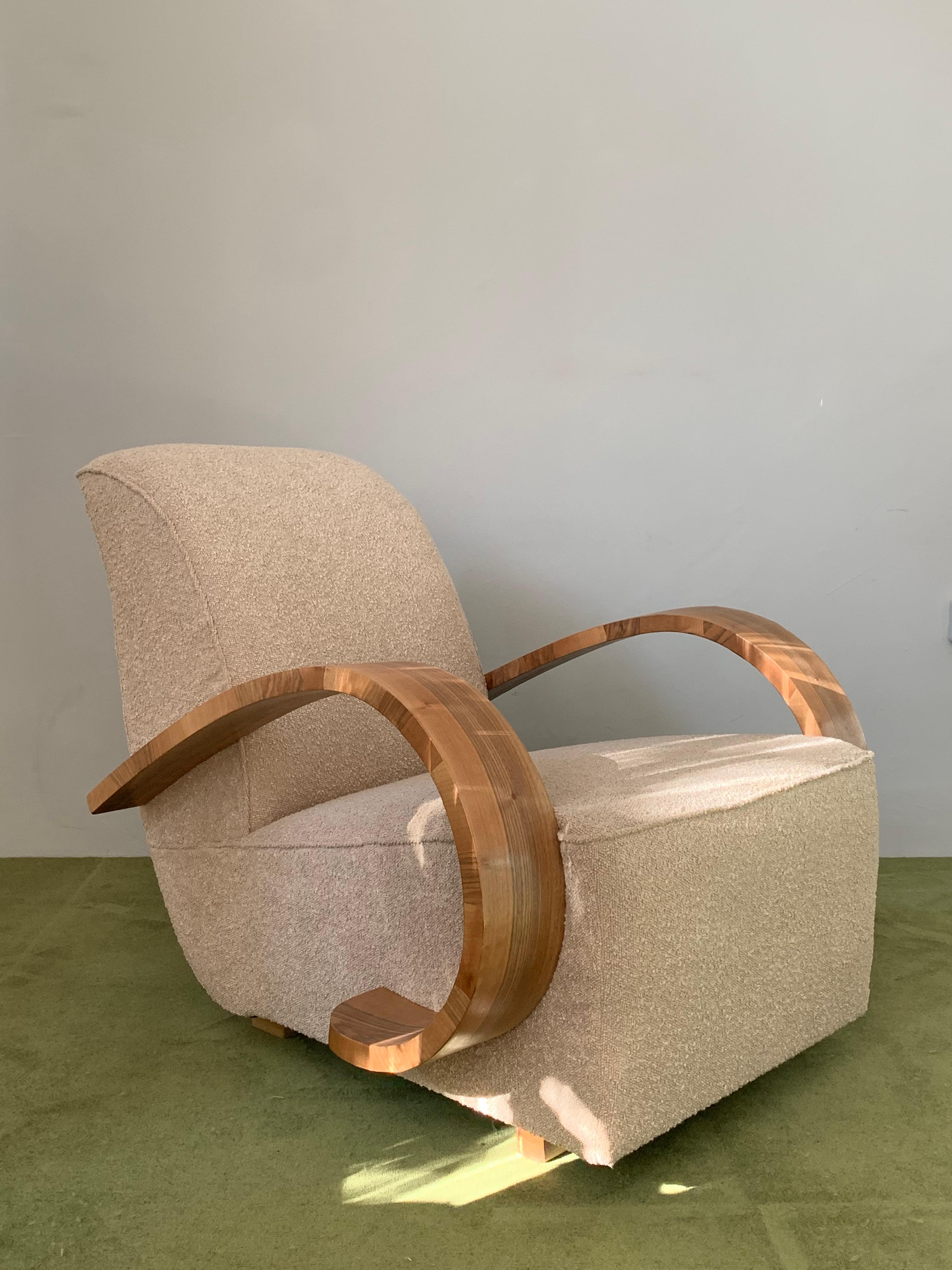 French origin art-deco armchair with restored veneered wooden arm avaliable.
The minimum essential restorations were made, the wooden arms were polished with satin finish and the chair was eupholstered with a curly taupe fabric. 
