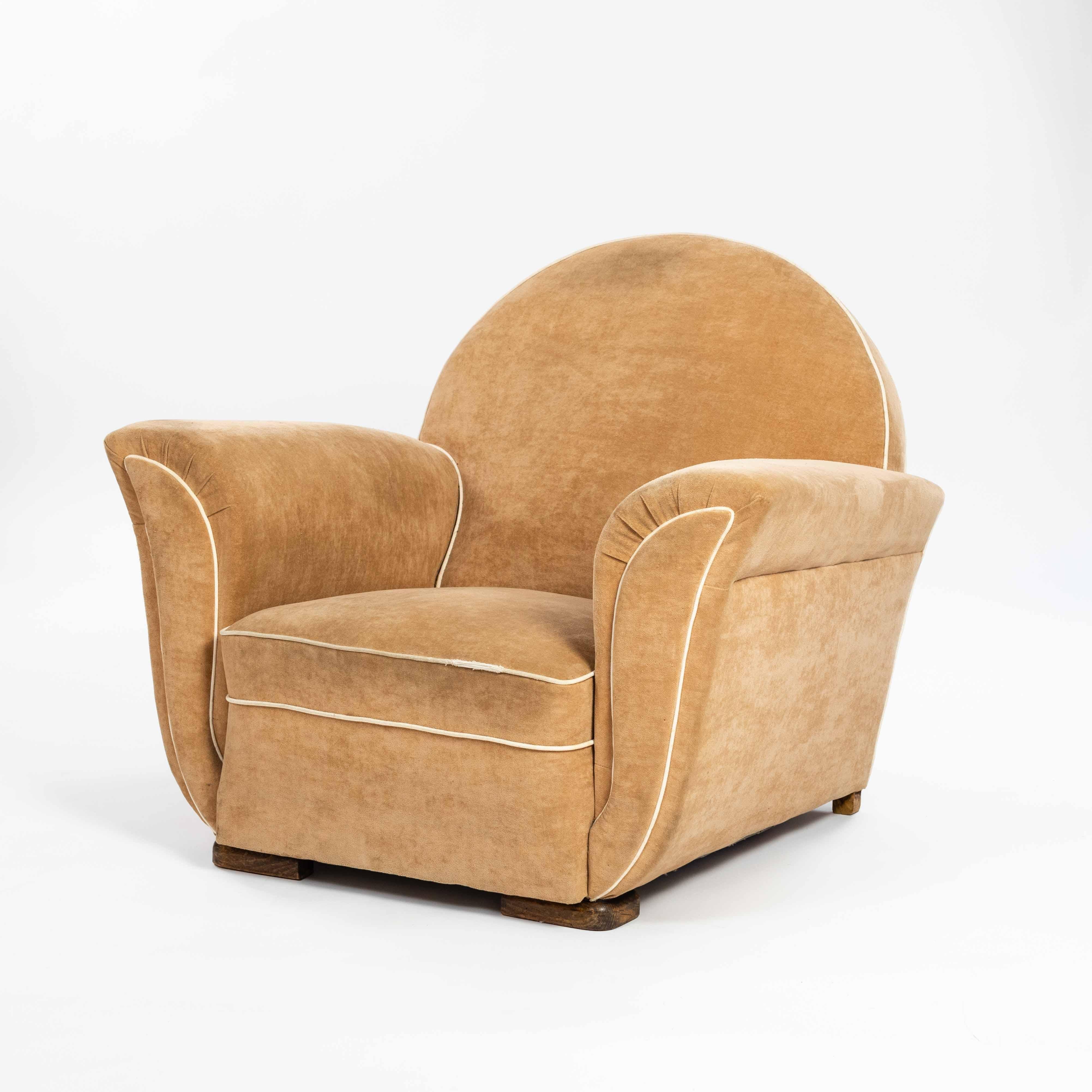 Pair of generous and rare Art Deco armchairs from France of the 1930-ies.
Like a tulip, the armchairs open sideways through the outwardly curved armrests, the incorporated piping emphasizes the shape again. Despite their stately size, the armchairs