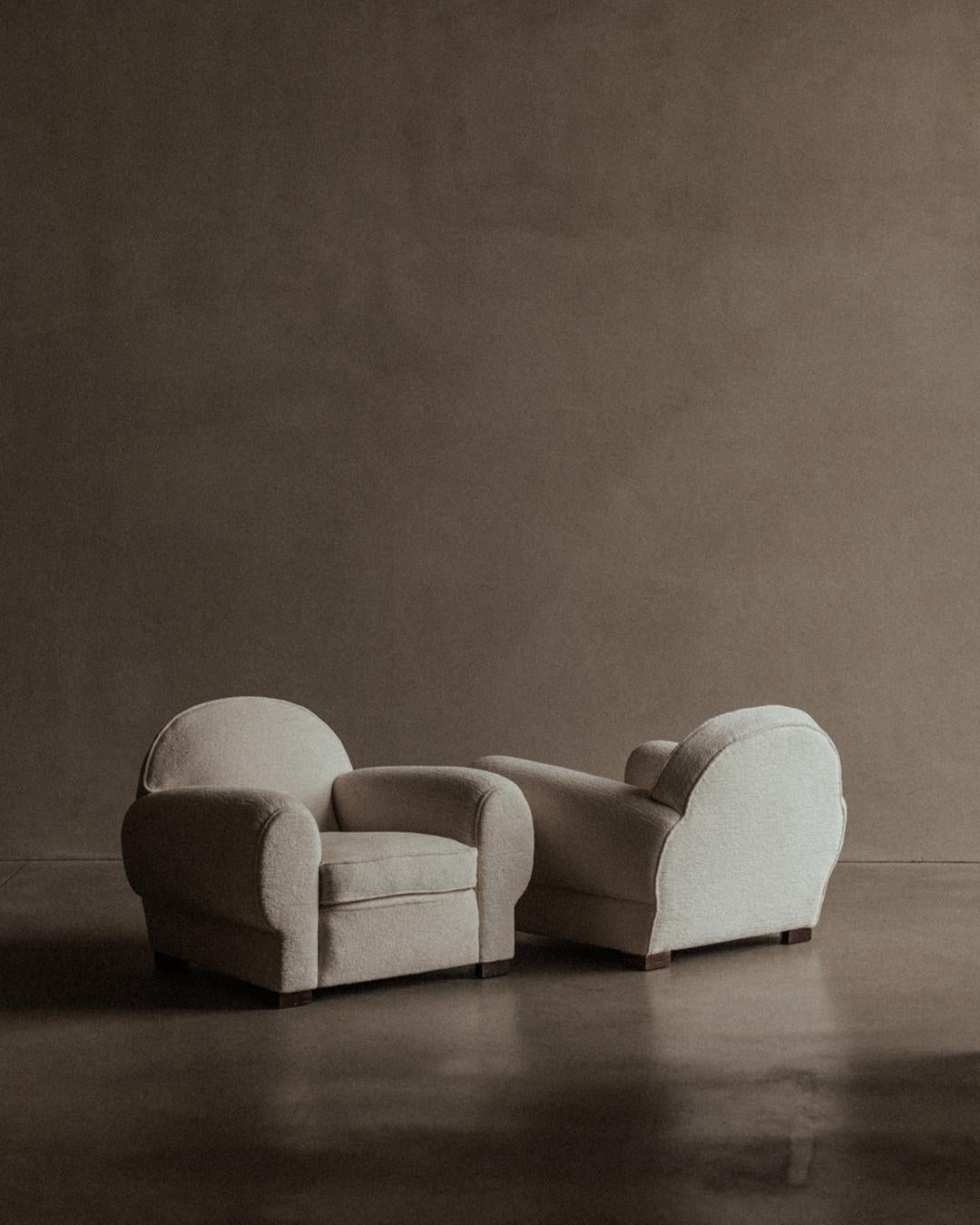 Pareja de sillones art déco franceses, con reposabrazos redondeados y silueta baja y envolvente. Retapizada en una chenilla de algodón blanco roto mezclada con alpaca, un tejido que desarrollará una pátina suave y elegante con el tiempo.

Los marcos