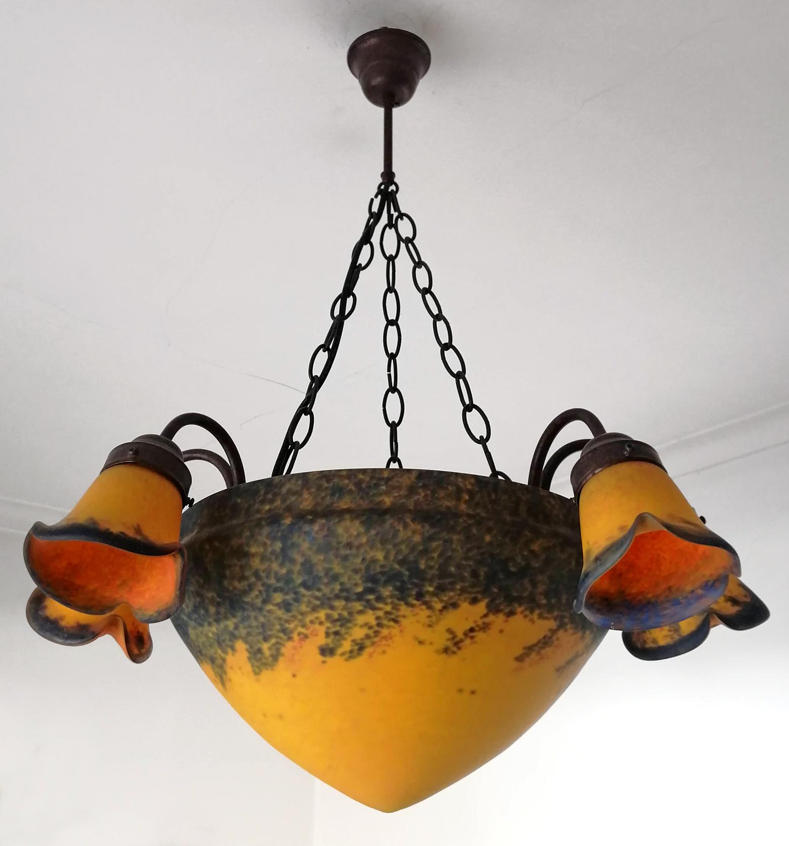 Beautiful original Art Deco chandelier made in France, signed Art de France. It features a mottled blown thick double glass large bowl shade and floral shaped glass shades in pâte de verre glass, in hues of orange fire, amber, red, blue and