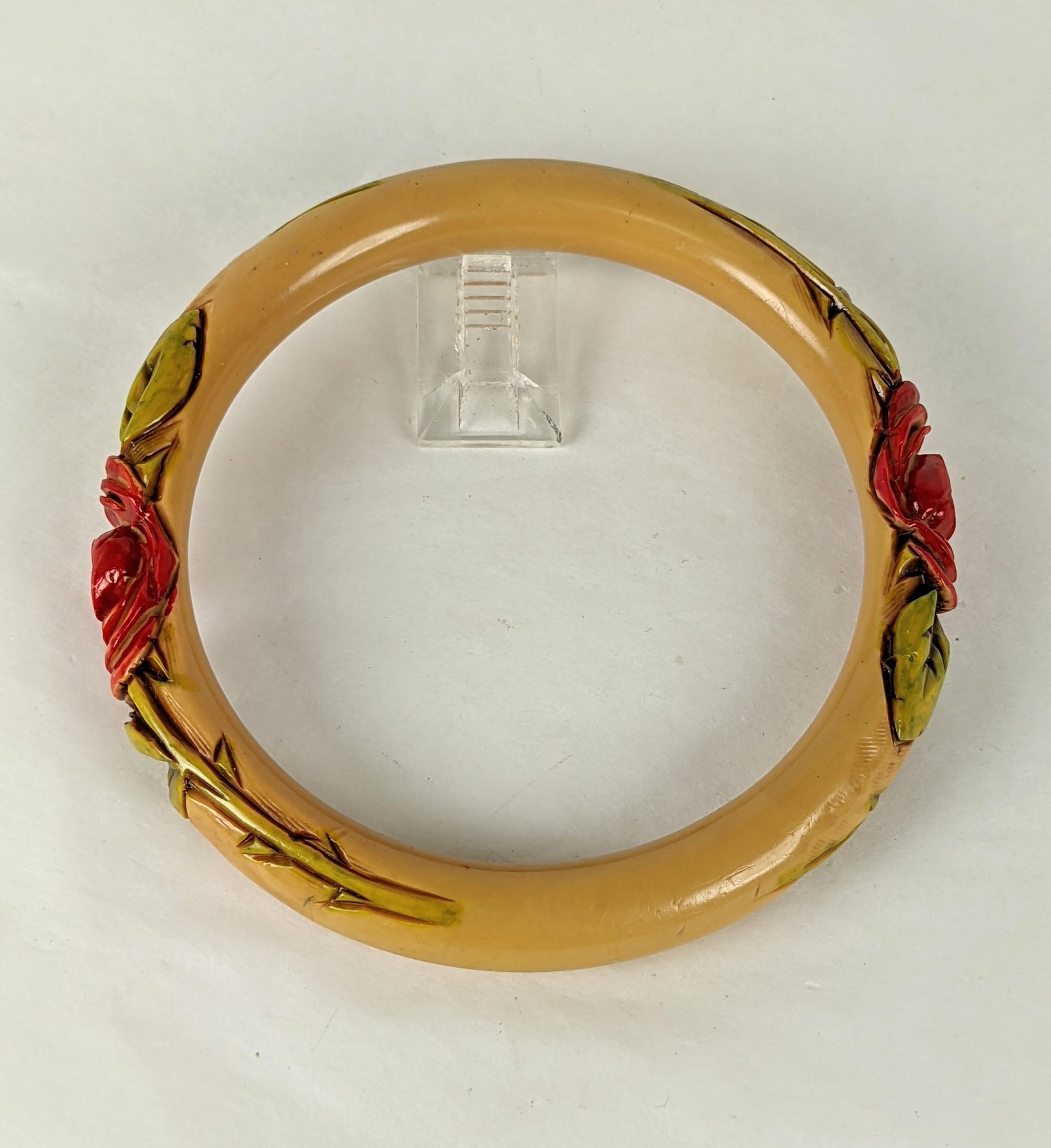 French Art deco carved bakelite rose bangle bracelet. The tubular cream color bracelet is hand carved with a sienna brown stain and cold painted with a deep pink unfurling rose and green stained leaves, rose stems, and thorns.
Excellent Condition.