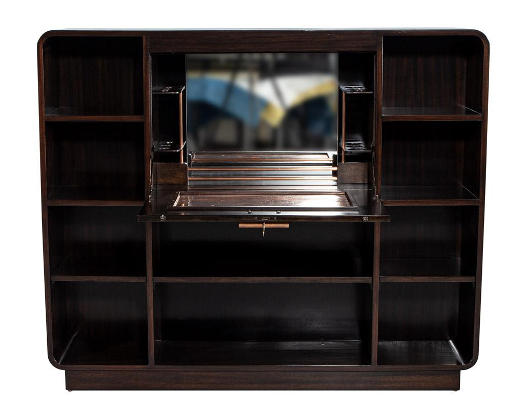 This beautiful French Art Deco bar cabinet from the 1950’s is an elegant piece of furniture that is sure to be the focal point of any room. Crafted from walnut with an eye-catching curved design, the cabinet has ten open shelves for displaying your
