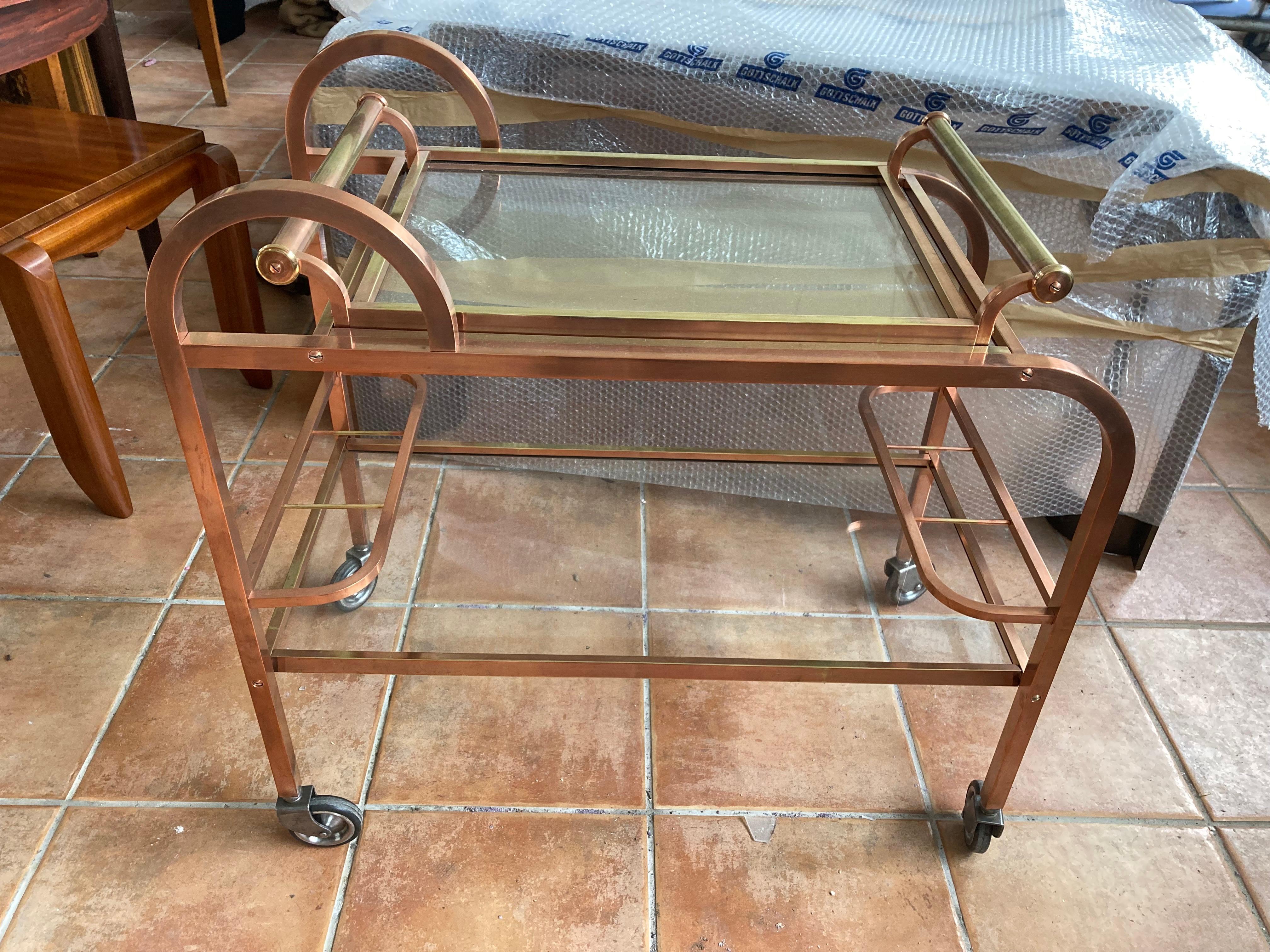 Elegant french Art Déco bar cart of the twenties.
Square tube, removable tray, glass shelves.
The bar trolley has a rare copper and brass alloy.
Heavy solid quality, the bar cart has been professionally polished.