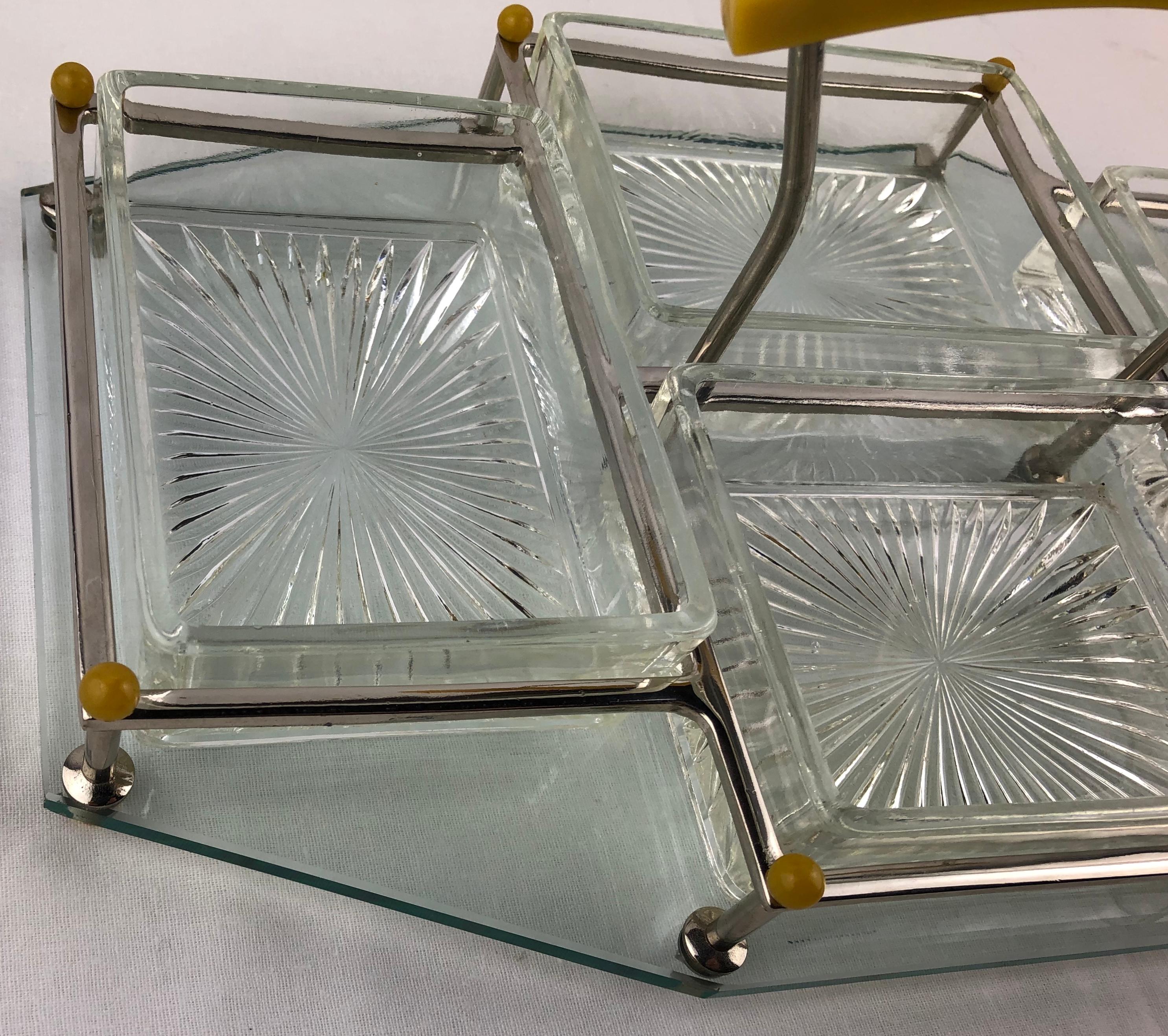 Elegante juego de bar Art Decó francés para servir entremeses, aperitivos o tentempiés. Dimensional, con un soporte o caddy cromado de dos pisos totalmente giratorio. Cuatro platos para servir, de cristal moldeado con un diseño esmerilado y grabado,