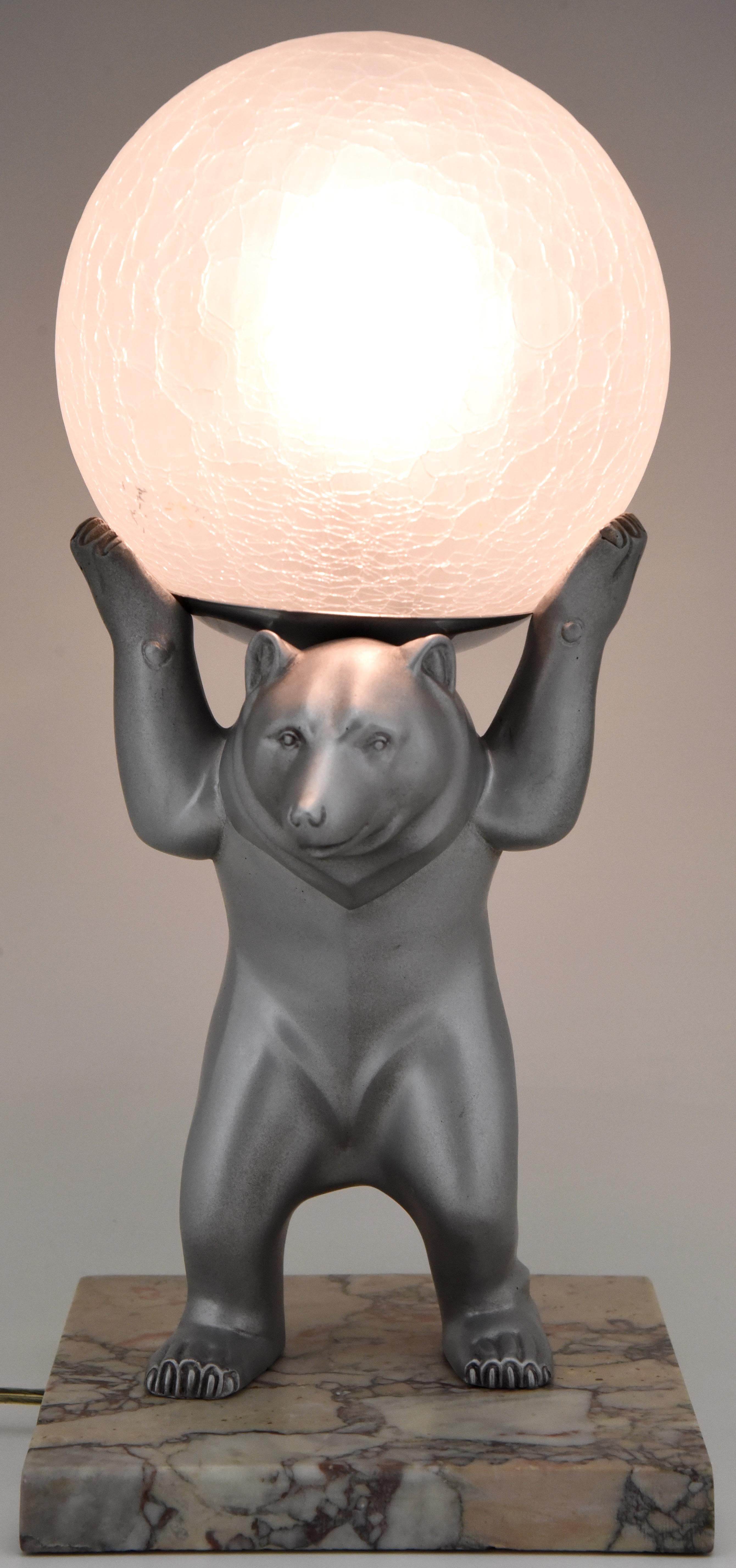 Lovely Art Deco lamp in the shapre of a bear with a ball balancing on his head. Signed by Rochard, France 1930. Art metal with silver grey patina, marble and crackle glass globe. 

Literature:? Animals in bronze by Christopher Payne. Antique